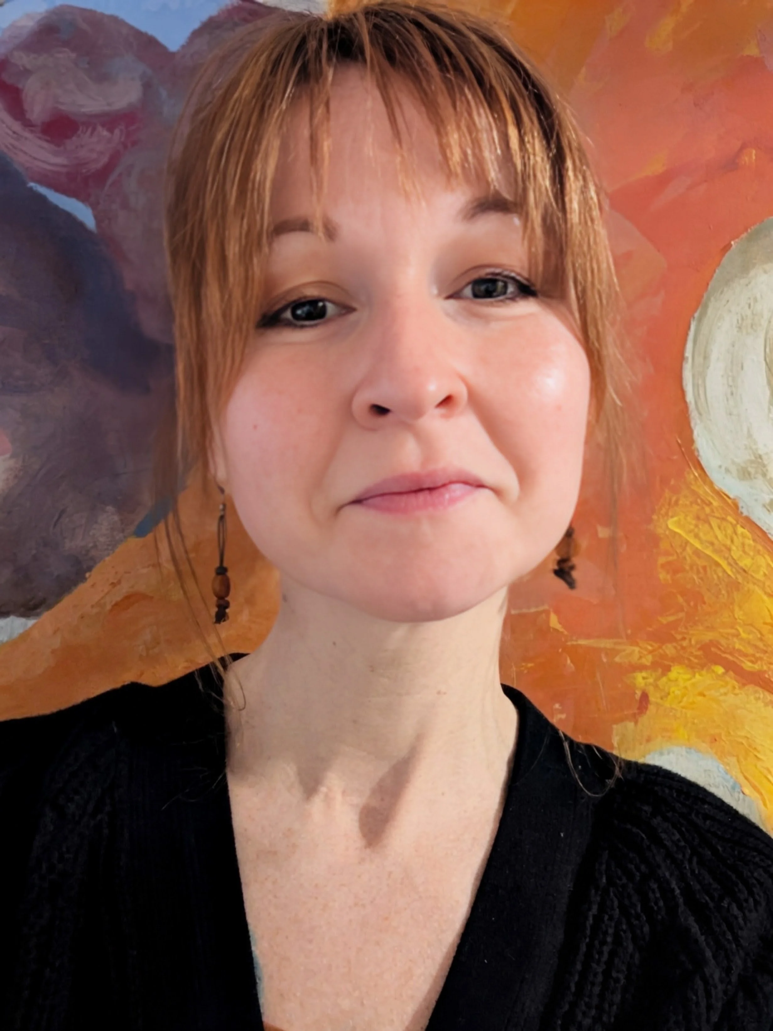 This is a photo of author Elisha Emerson. She has bangs and is wearing dangling earrings.