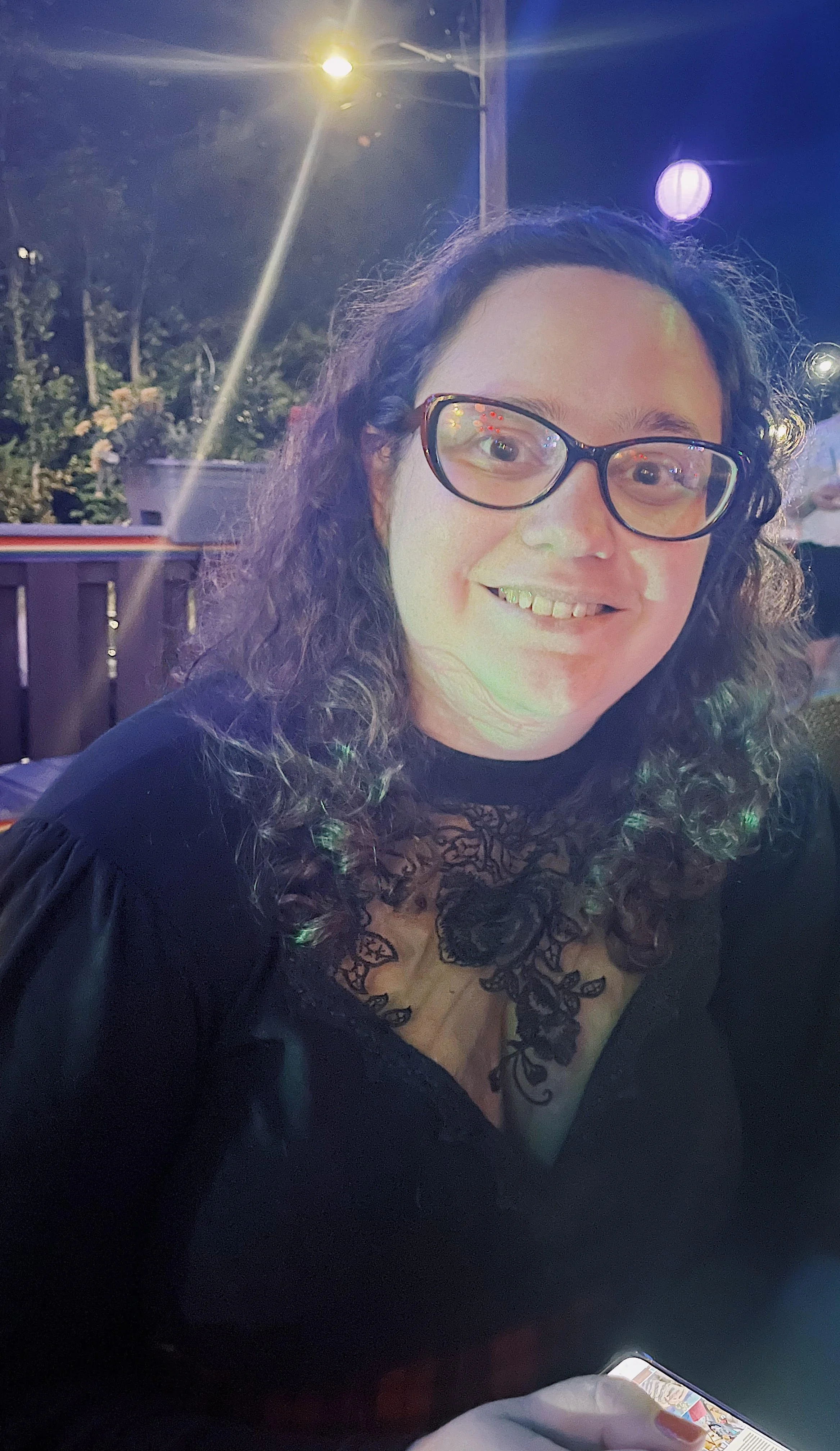 A headshot of Melissa, who has dark curly hair and glasses.
