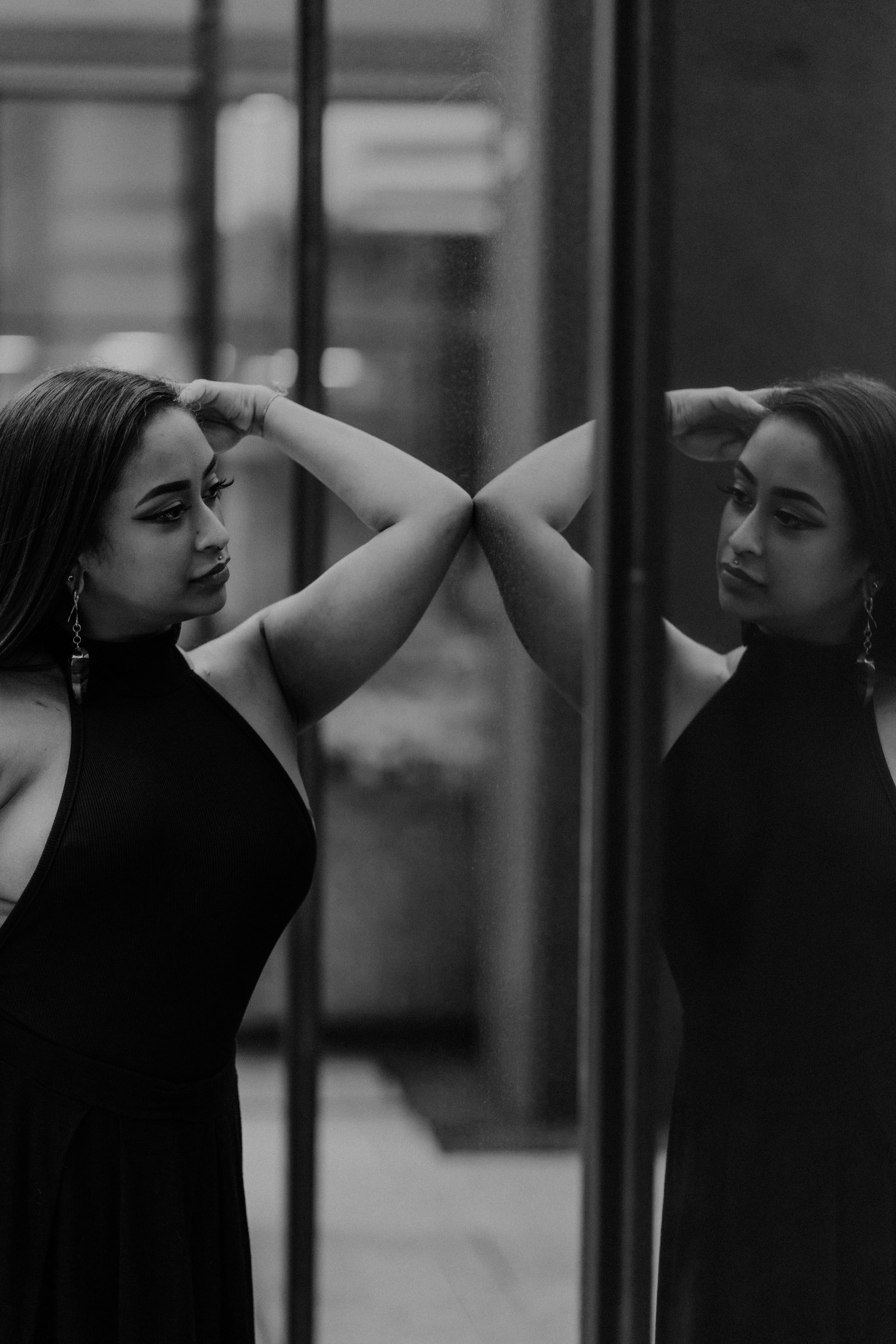 An artistic black-and-white shot of Rita looking at her reflection in a surface.