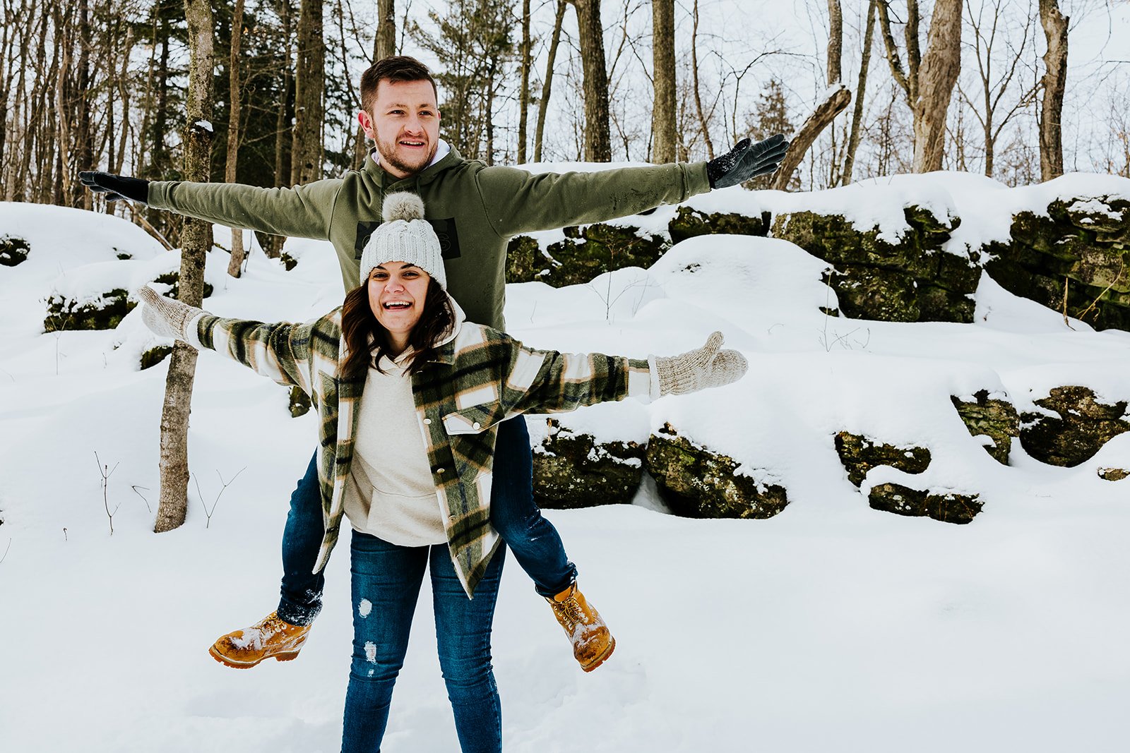 Engaged couple plays in the snow in winter engagement photoshoot photo by Fedora Media.jpg