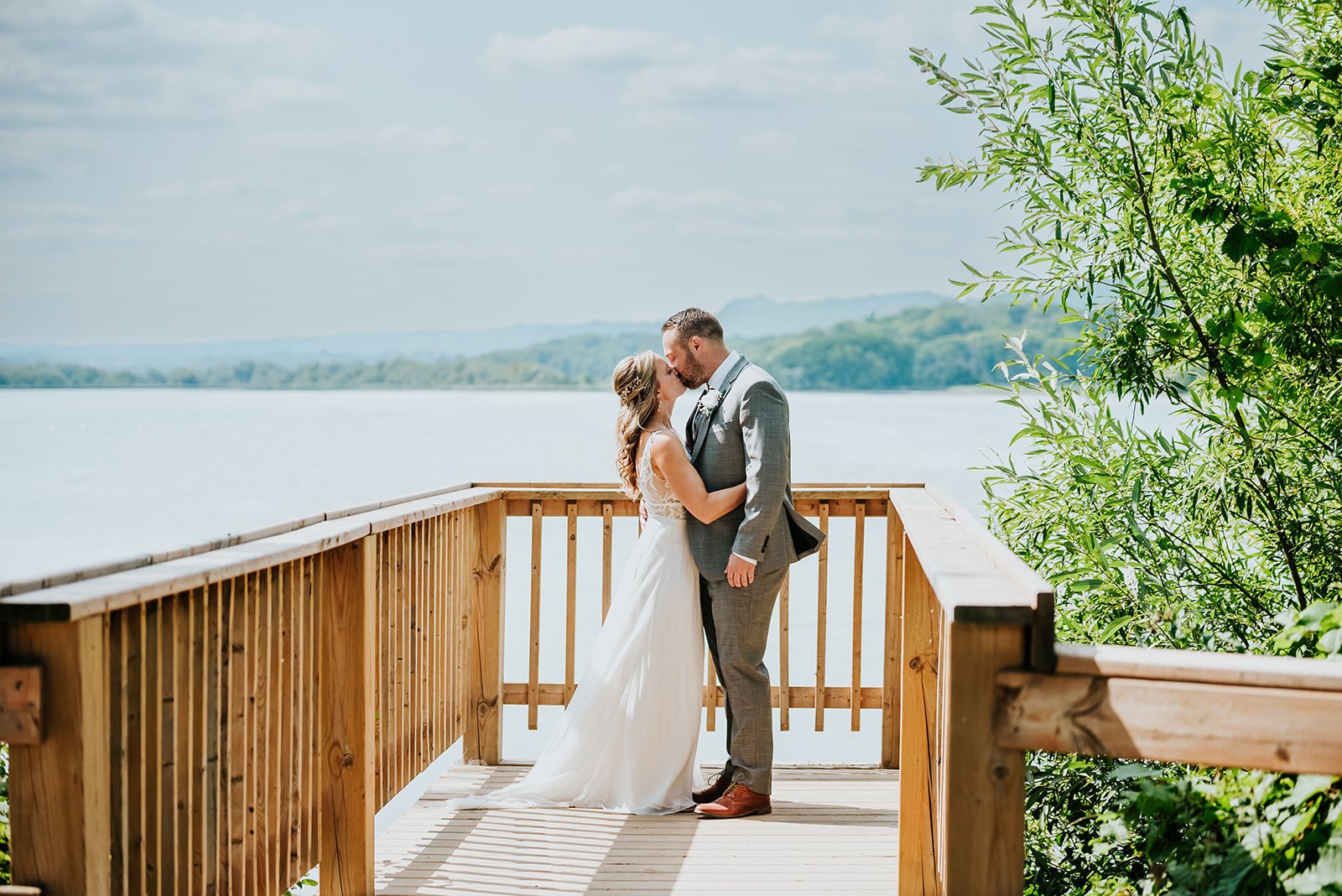 Bride and groom share a kiss at the lake photo by Fedora Media.jpg