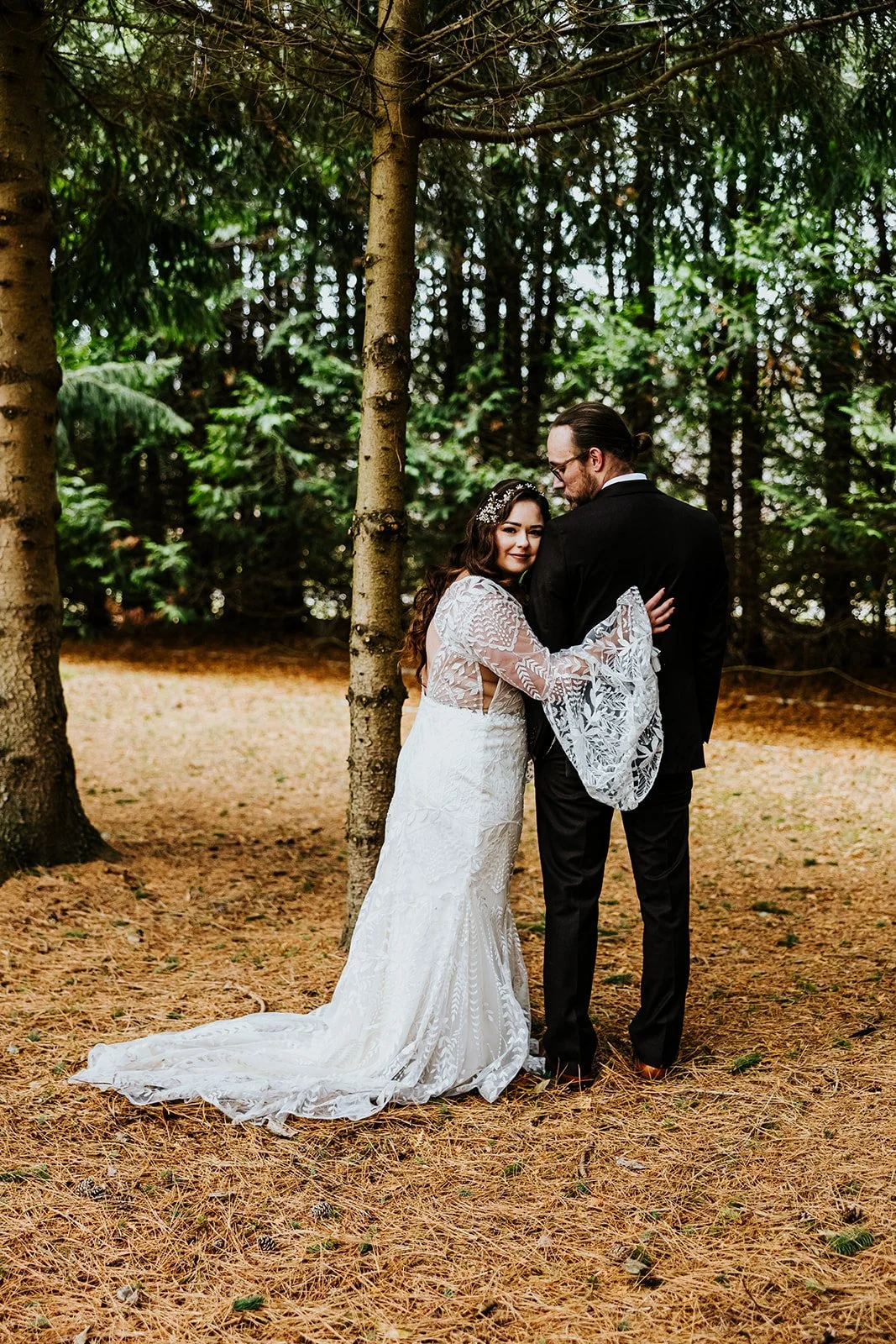 Groom in a black suit looks over his shoulder at the bride photo by Fedora Media.jpg
