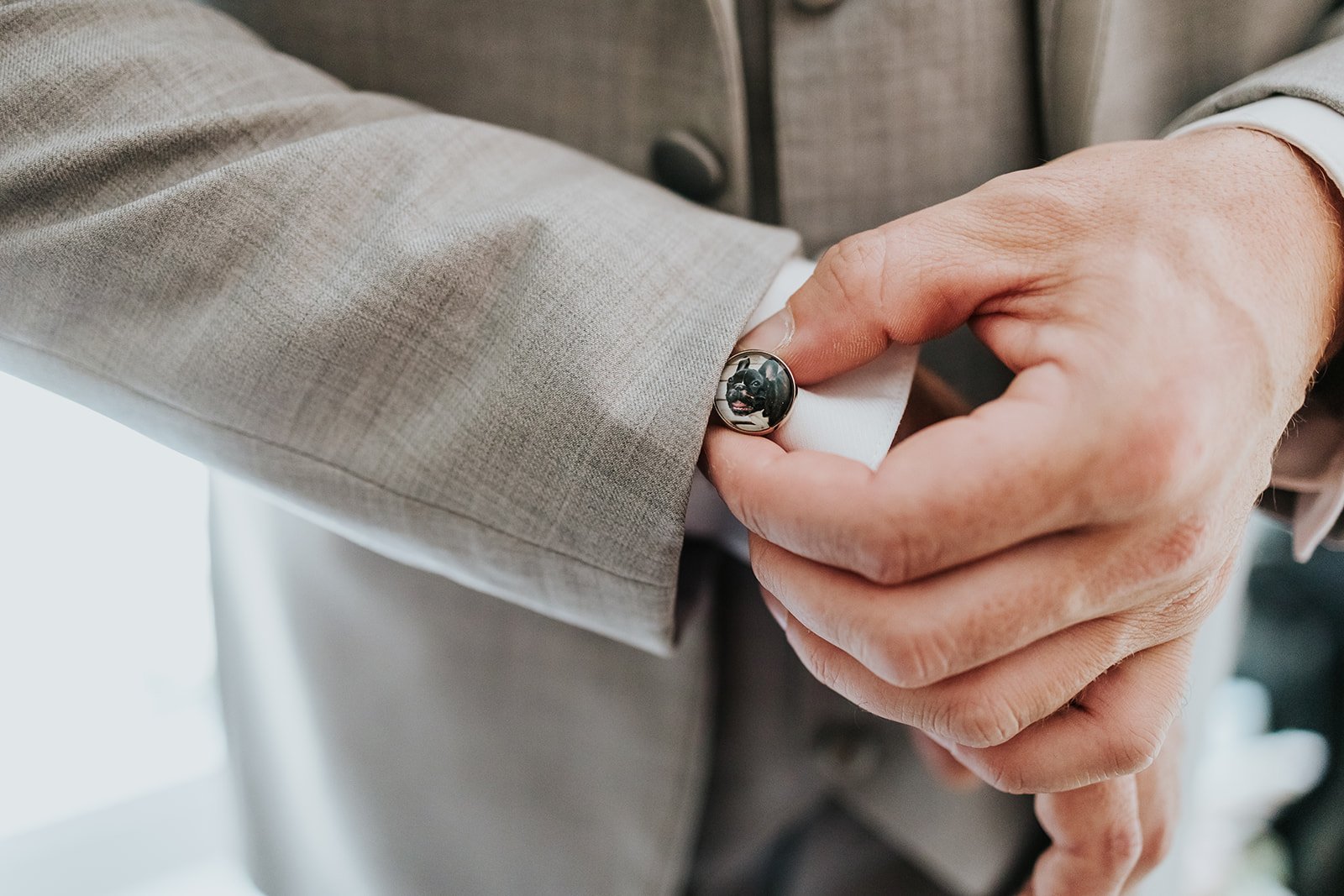 Groom in grey suit adjust custom cufflinks photo by Fedora Media.jpg