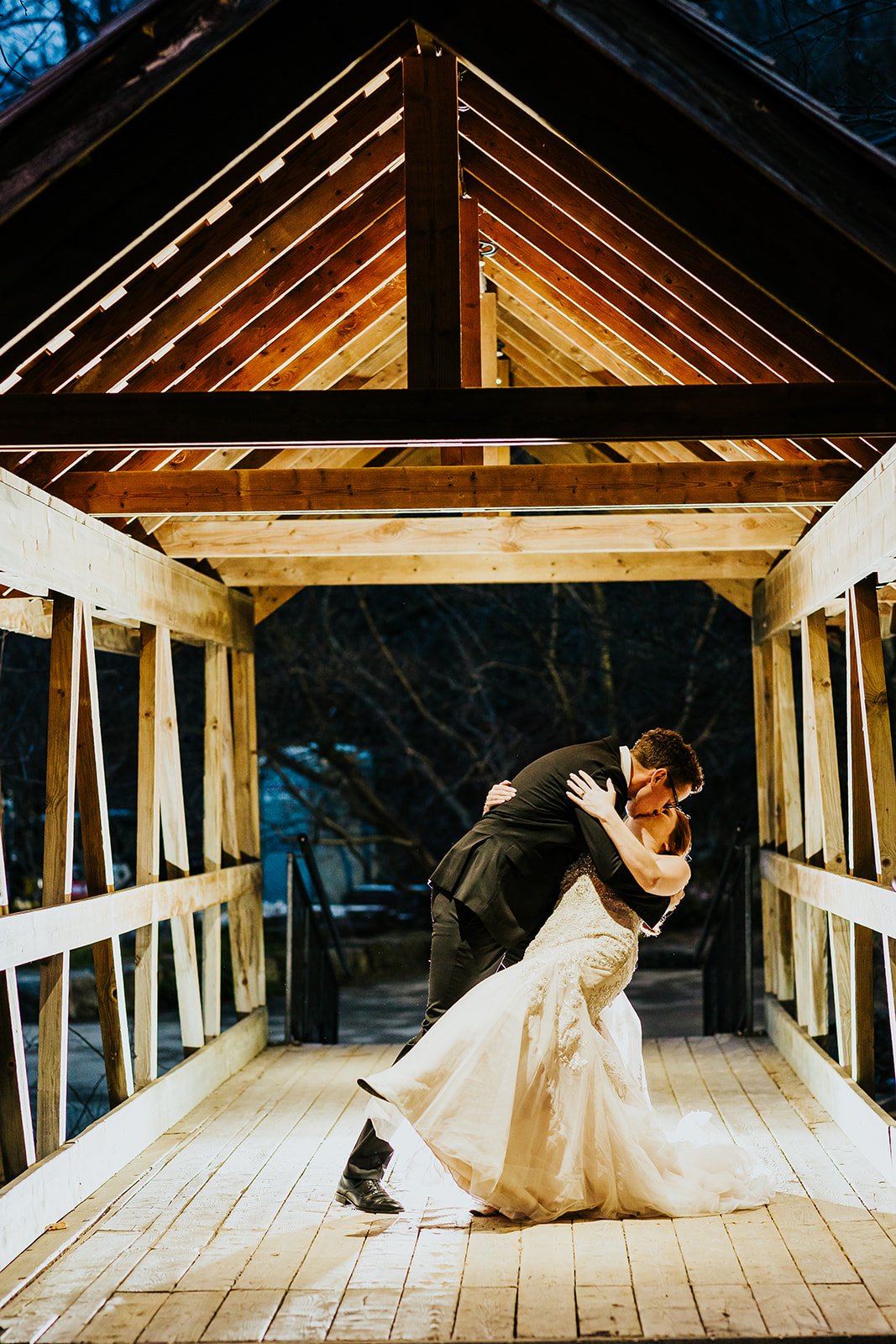Groom dips bride for a kiss at nighttime photoshoot at the Ancaster Mill photo by Fedora Media.jpg