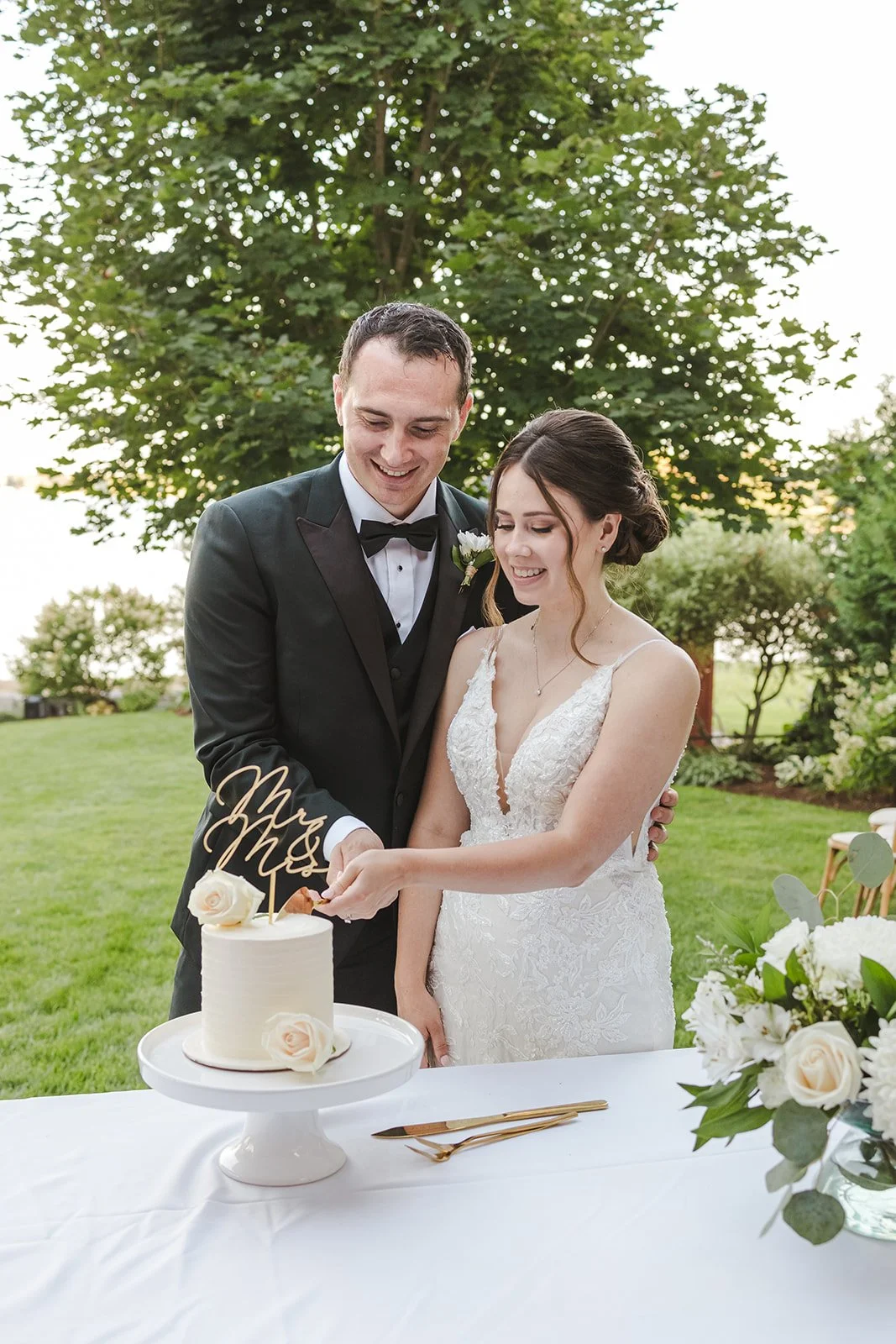 Bride and Groom Share Smiles During Wedding Cake Cutting  Fedora Media  Backyard Wedding.jpg