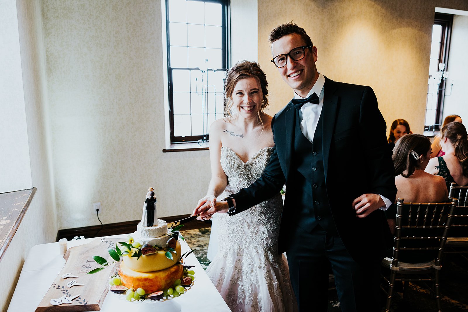 Bride and groom cut cake made of cheese at the Ancaster Mill photo by Fedora Media.jpg
