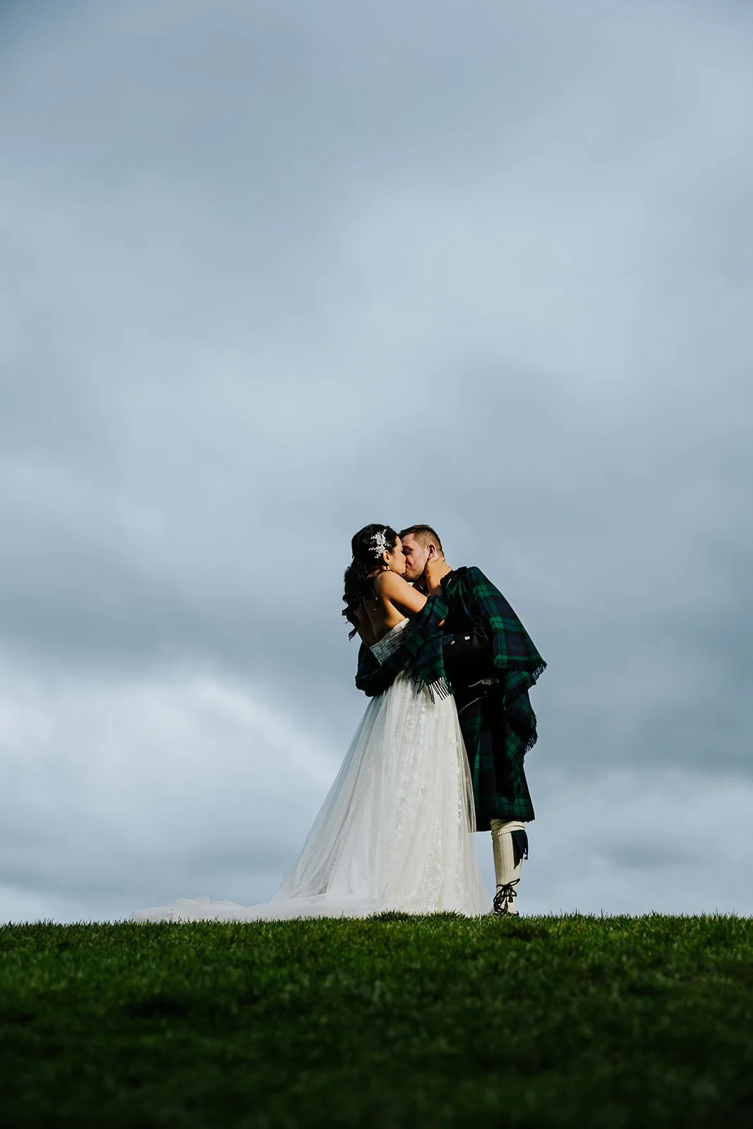 Bride and groom kiss with dramatic background at Whistle Bear Golf Club photo by Fedora Media.jpg