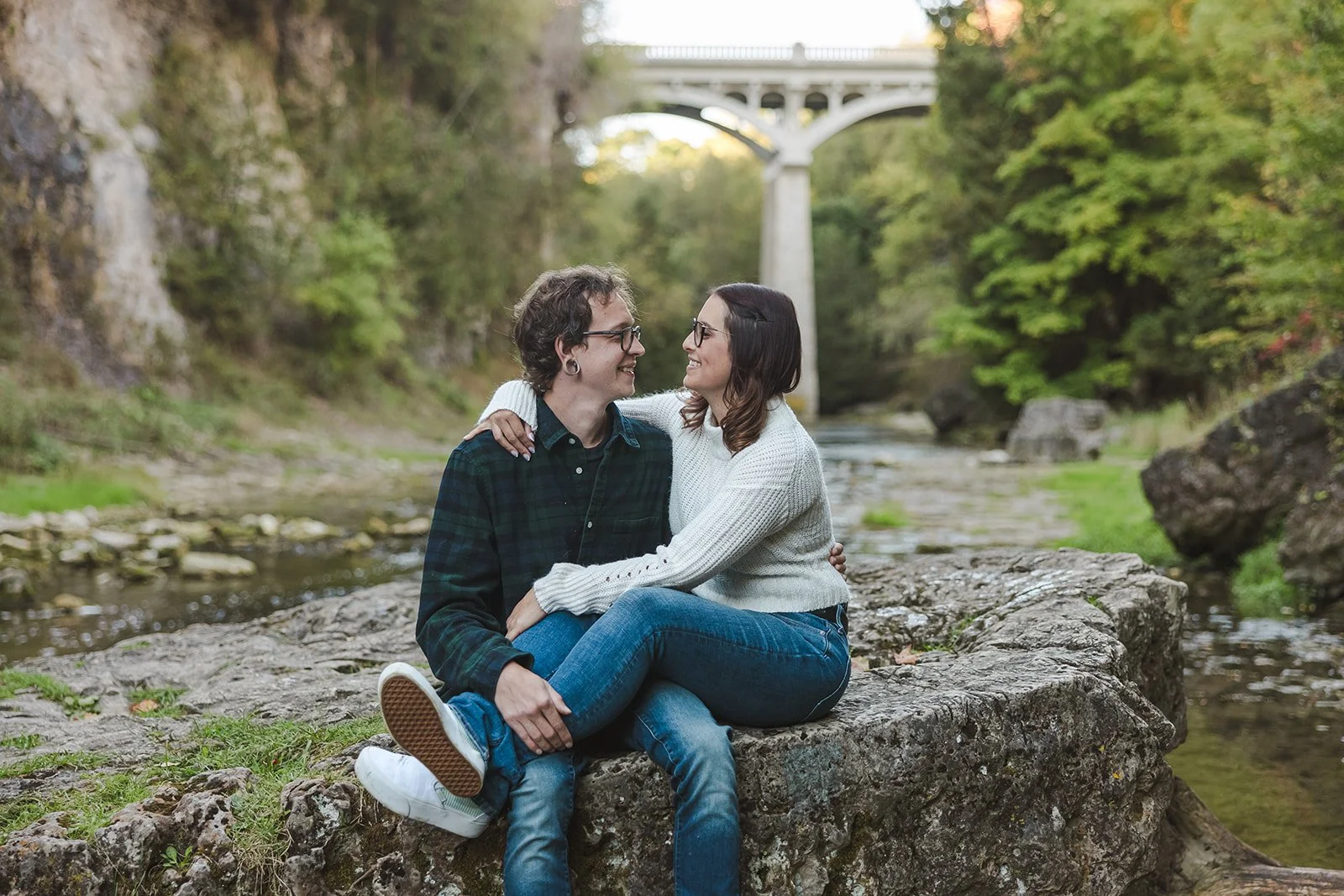 Engaged Couple Lock Eyes For Intimate Moment on Rock in River Fedora Media Elora Ontario.jpg