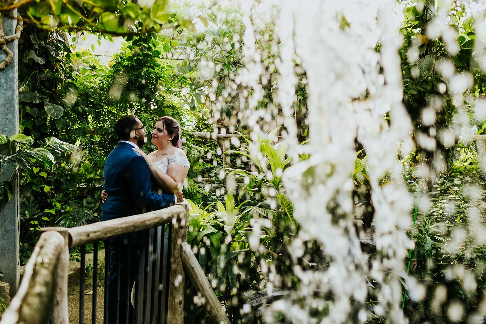 Bride and groom under waterfall at Cambridge Butterfly Conservatory photo by Fedora Media.jpg