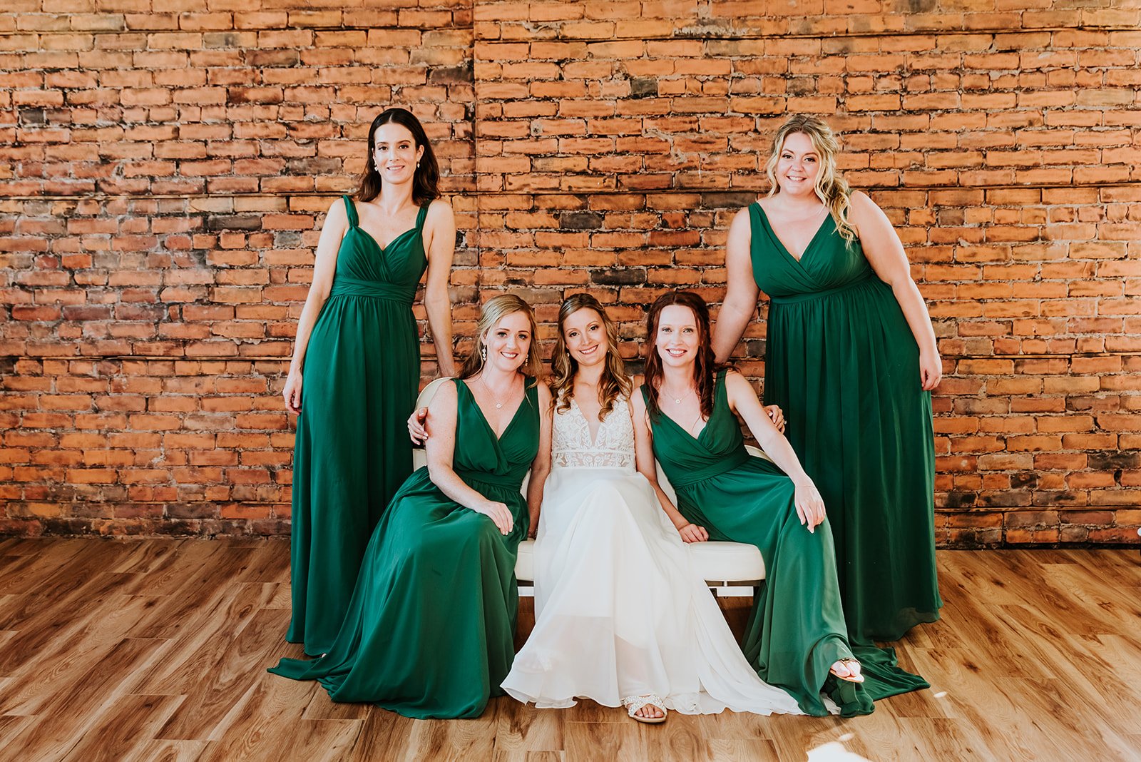 Bride poses with bridesmaids in emerald green dress photo by Feoda Media.jpg