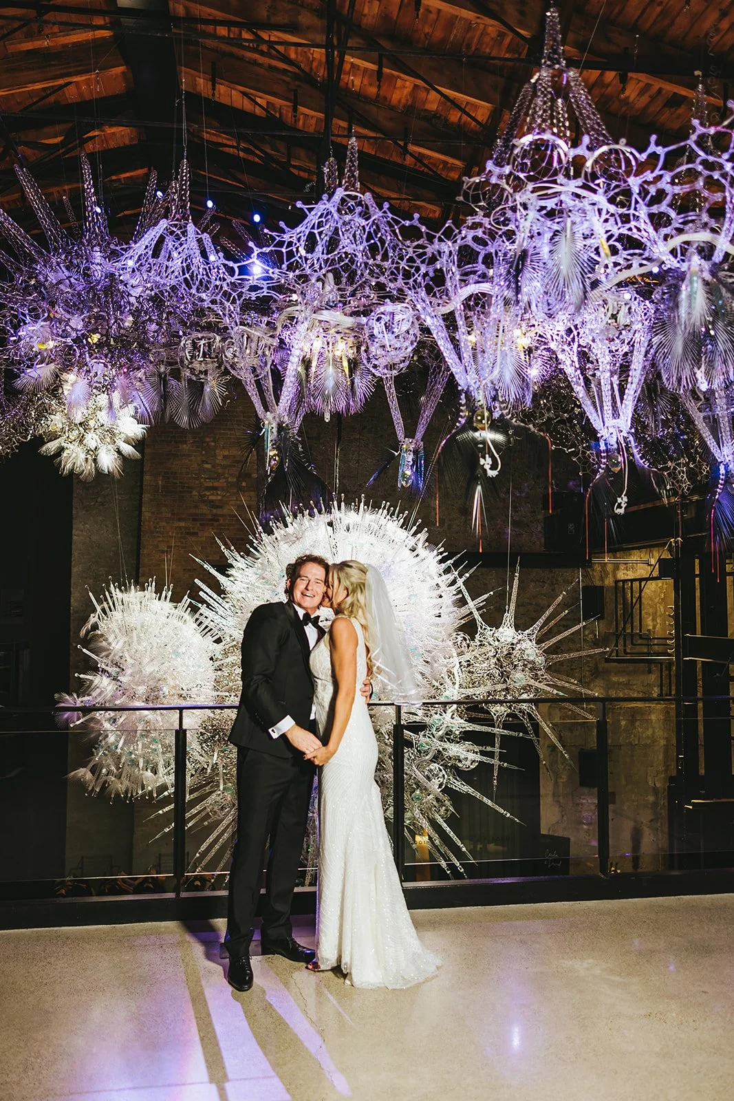 Bride kisses groom on the cheek on Tappistry Hall Balcony Photo by Fedora Media.jpg