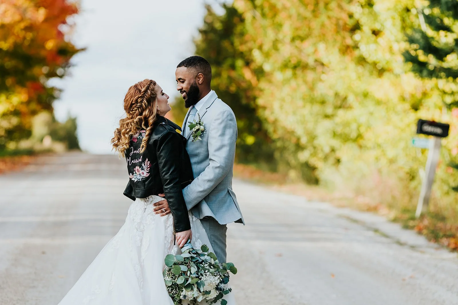 Bride wears a leather jacket and poses with her husband photos by fedora media.jpg