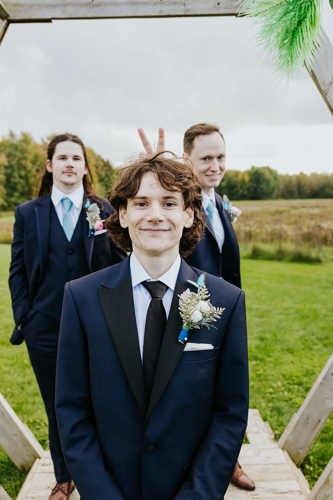 Groom in a blue suit and black tie with his groomsmen photo by Fedora Media.jpg