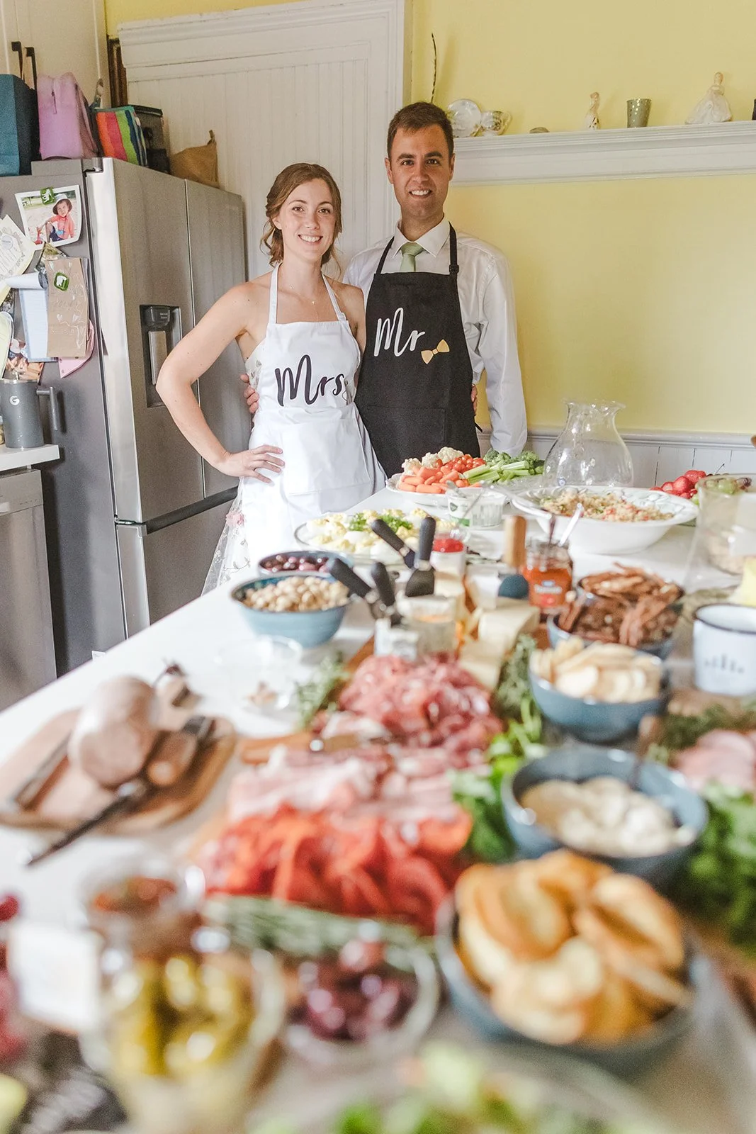 Bride and Groom Pose in Kithchen with Mr and Mrs Aprons  Fedora Media.jpg
