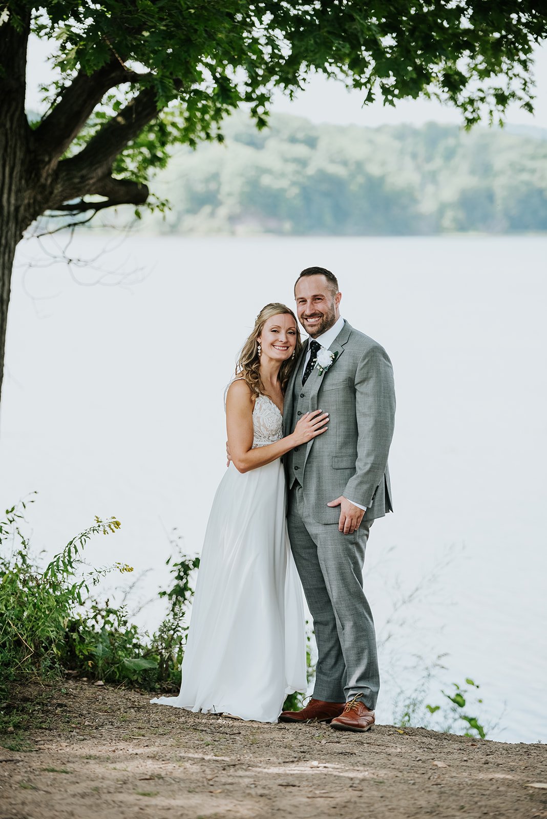 Bride and groom pose by the lake for wedding photoshoot photo by Fedora Media.jpg