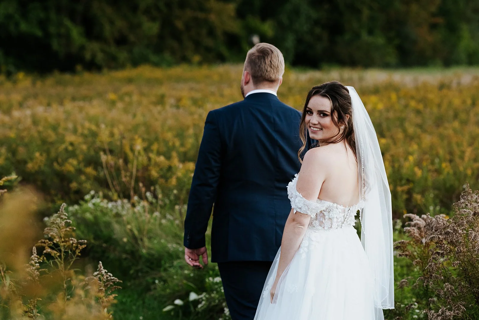 Bride and groom in fall colour field photo by Fedora Media.jpg