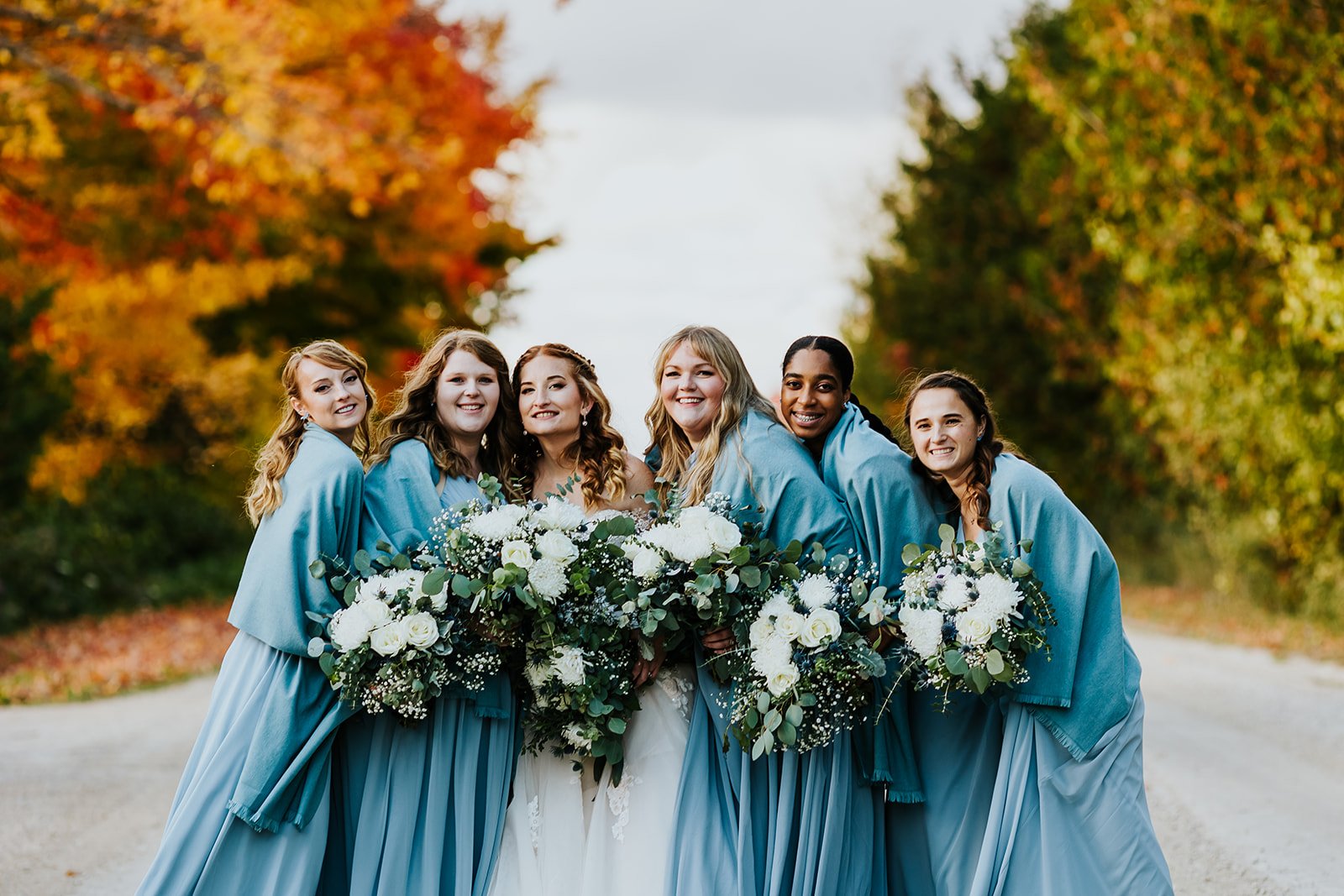 Bride and bridesmaids in blue dresses for fall wedding photos by fedora media.jpg