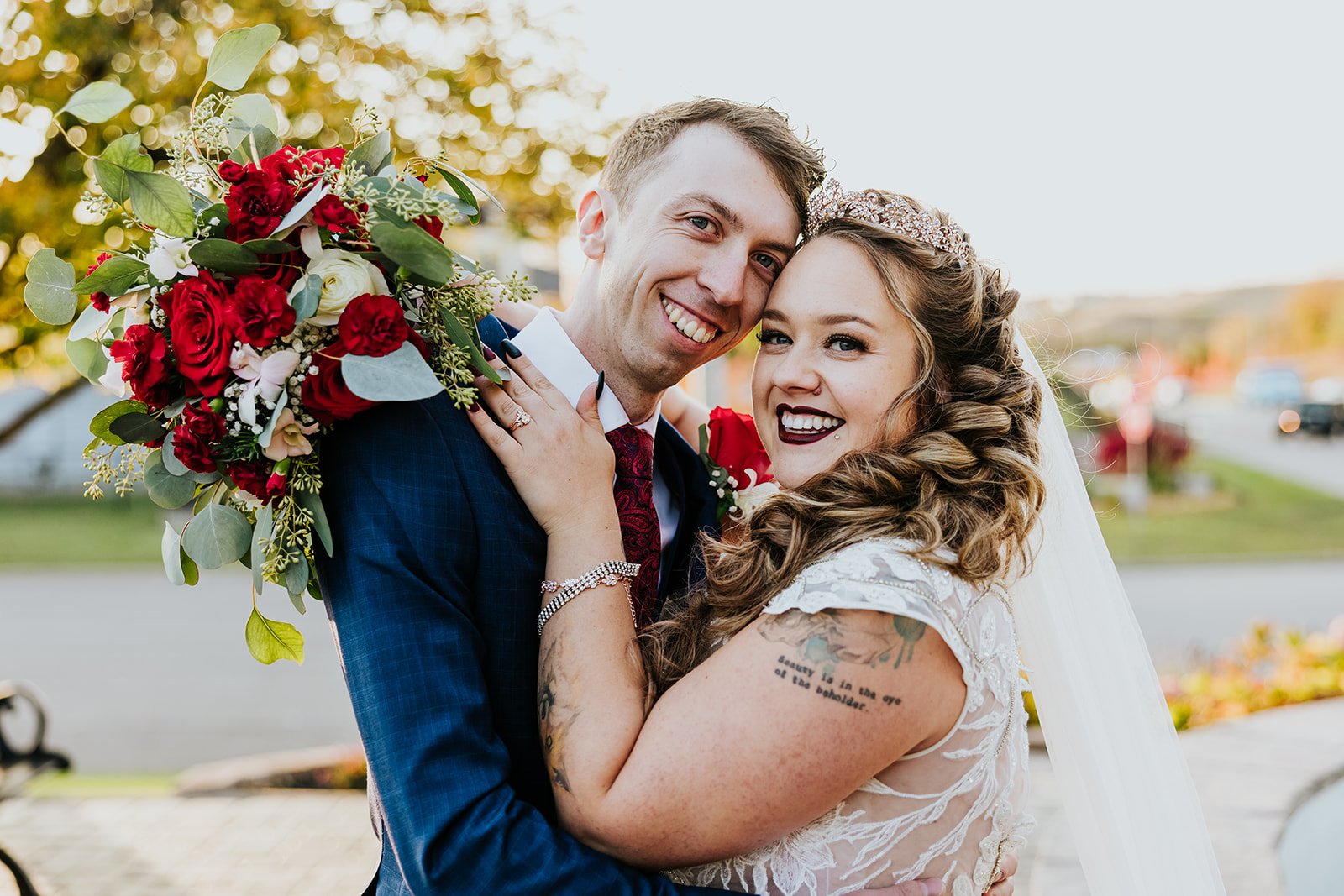 Tattoo bride poses with the groom in blue suit in Hamilton photo by Fedora Media.jpg