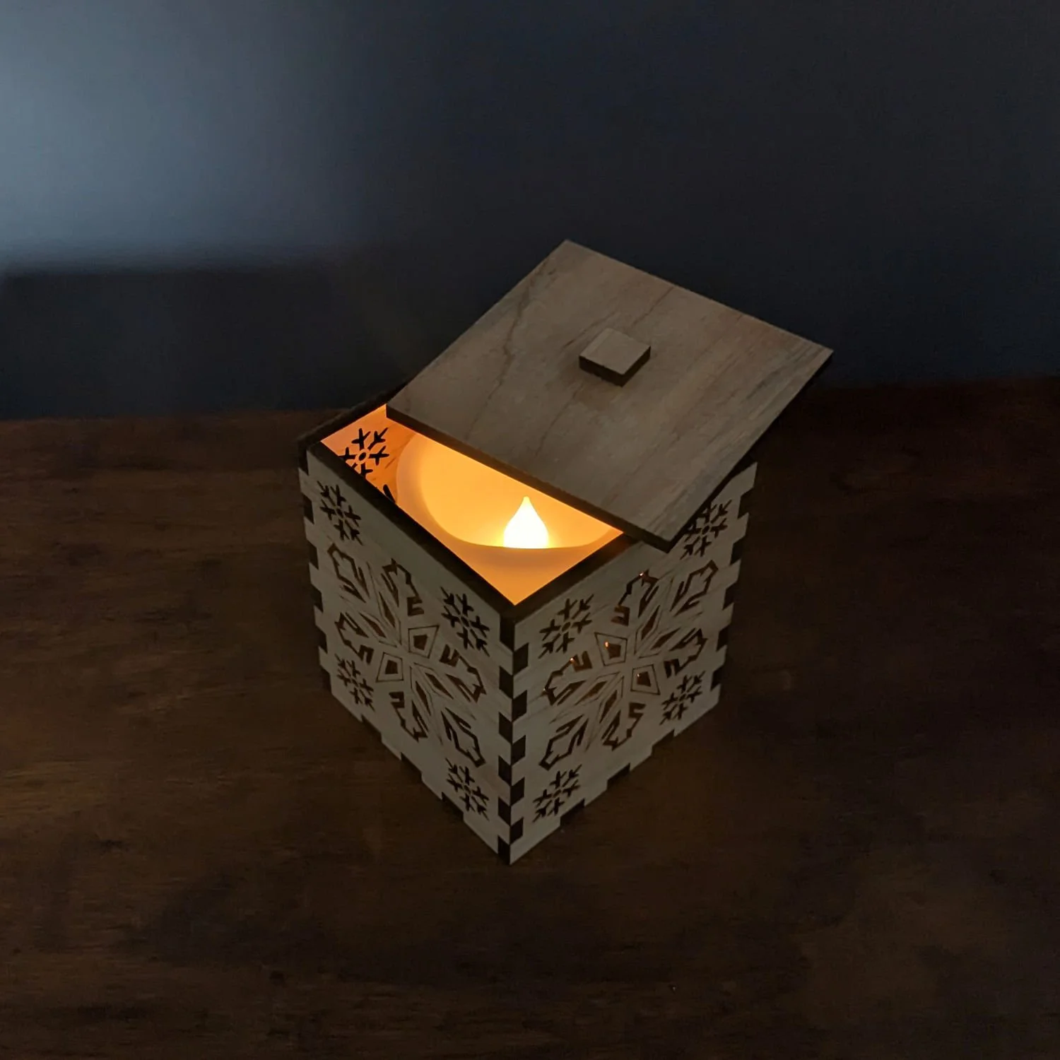 Maple Snowflake Lantern glowing in a dim room, showing cozy winter ambiance.