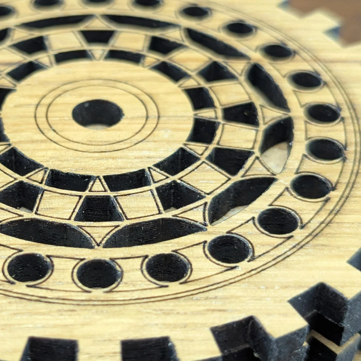 Close-up of The Engineer wooden coaster highlighting precision laser-cut gear details and engraved patterns.