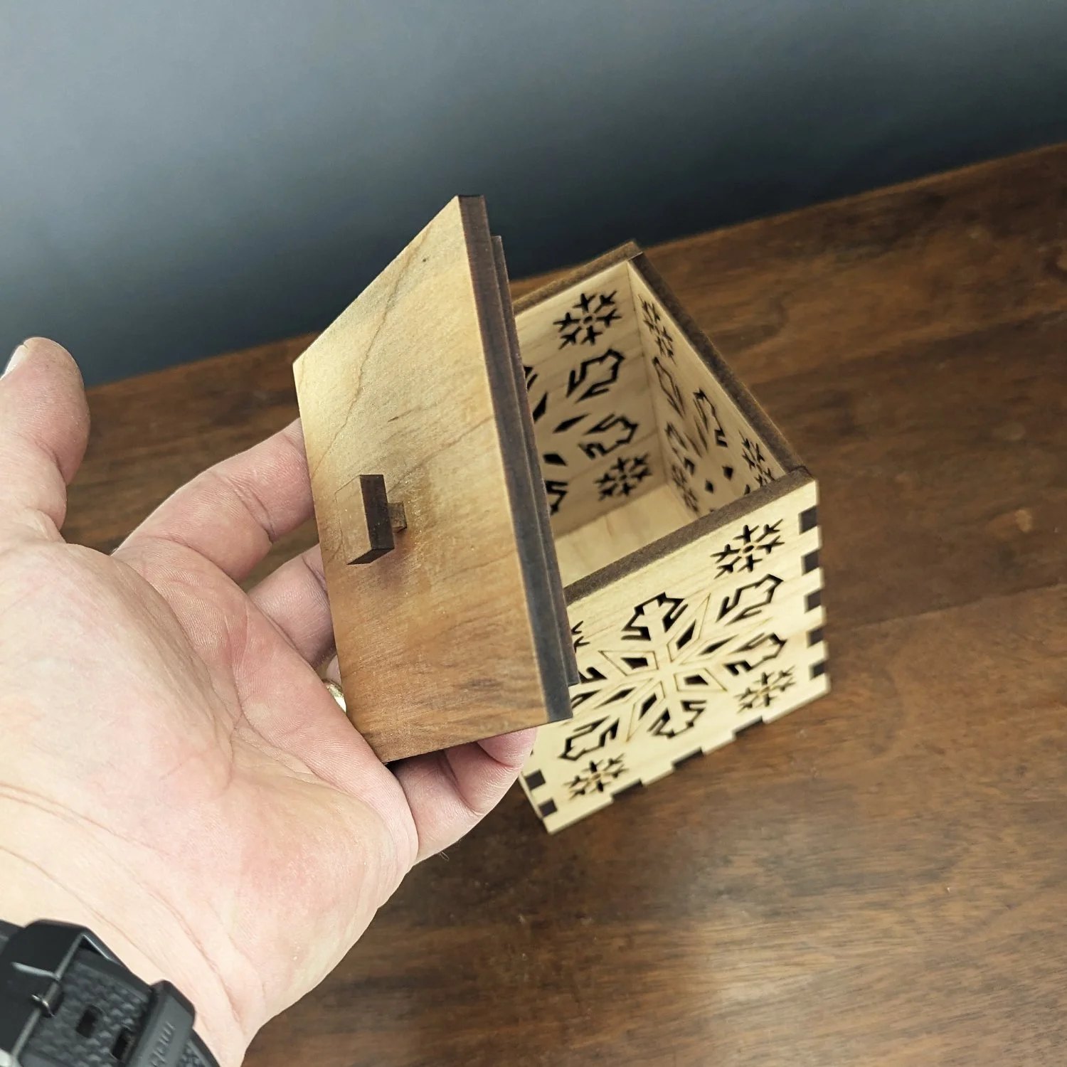 Close-up of the Maple Snowflake Lantern lid with maple knob and laser-cut edges.