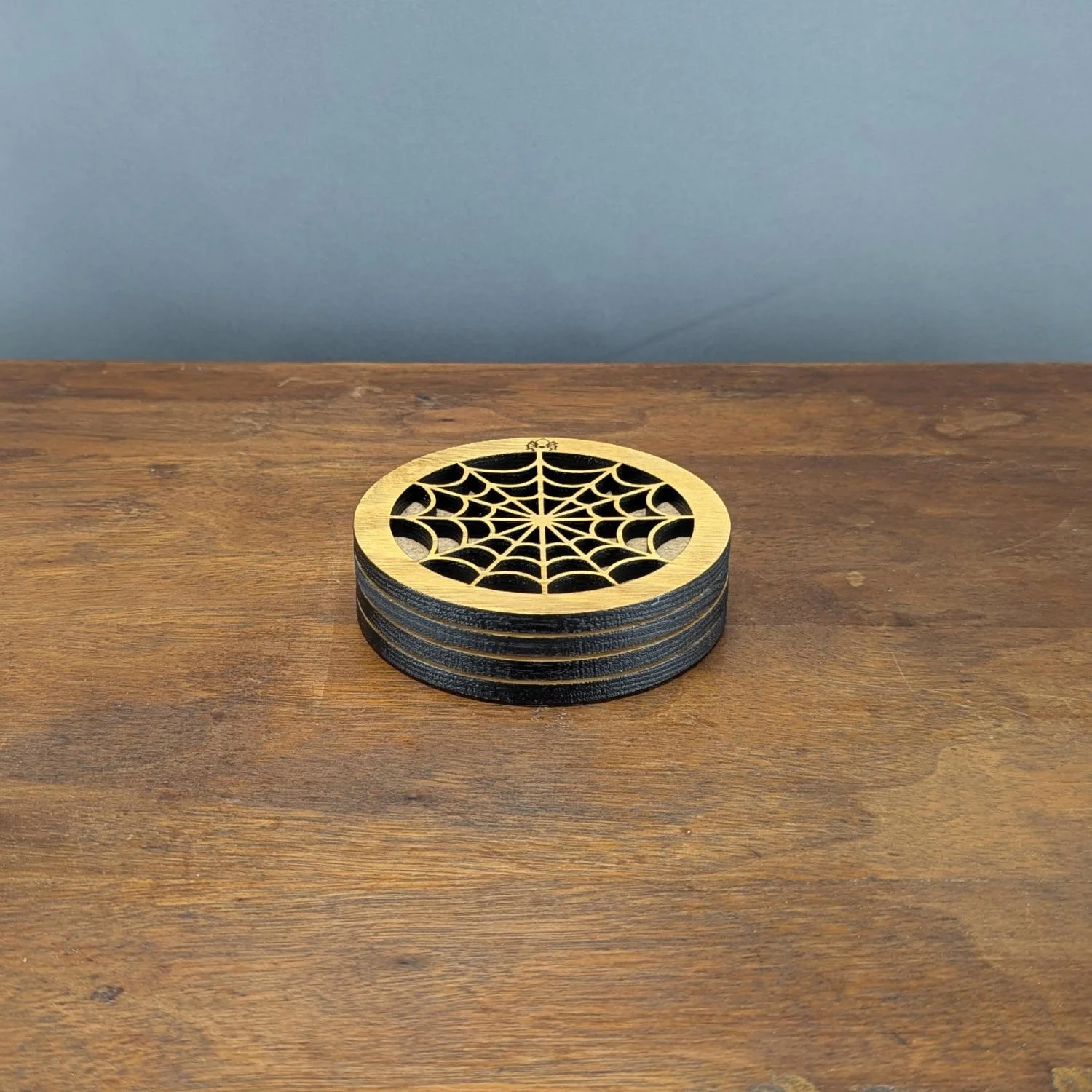 Stack of Lace Web coasters placed directly on a table, showing spiderweb design.