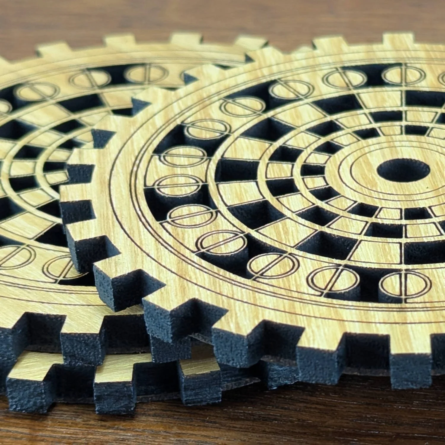 Three stacked Operator wooden gear coasters on a wooden table, highlighting engraved screw-like details.