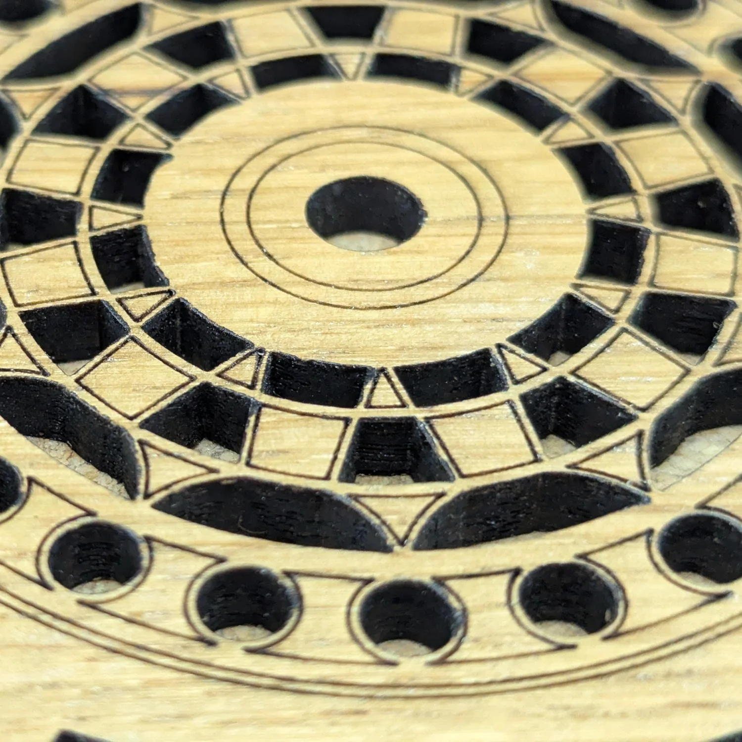 Close-up of The Engineer wooden coaster highlighting precision laser-cut gear details and engraved patterns.