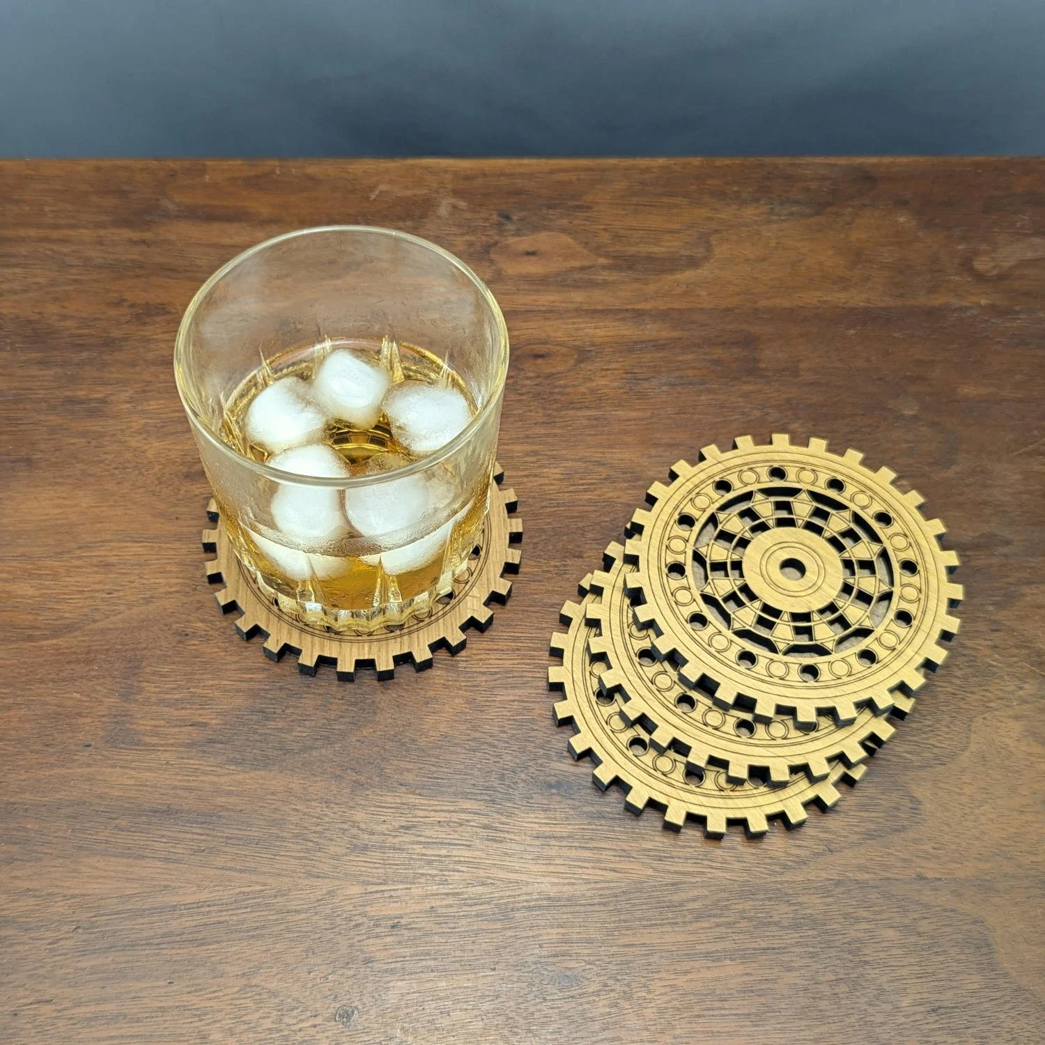 Machinist coaster under a glass of iced whiskey