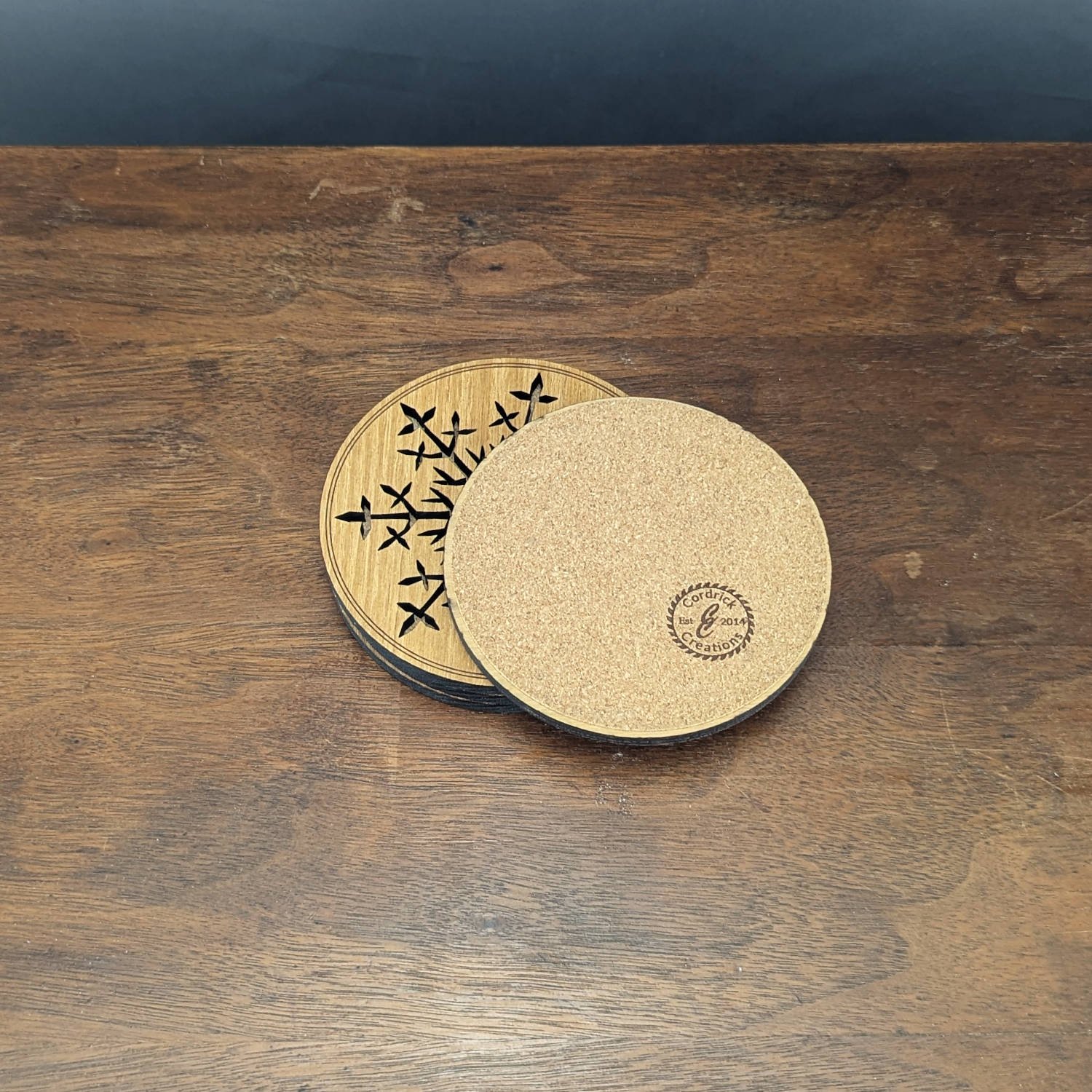 Black Locust snowflake coasters shown with one flipped to reveal the cork backing and Cordrick Creations logo stamp.