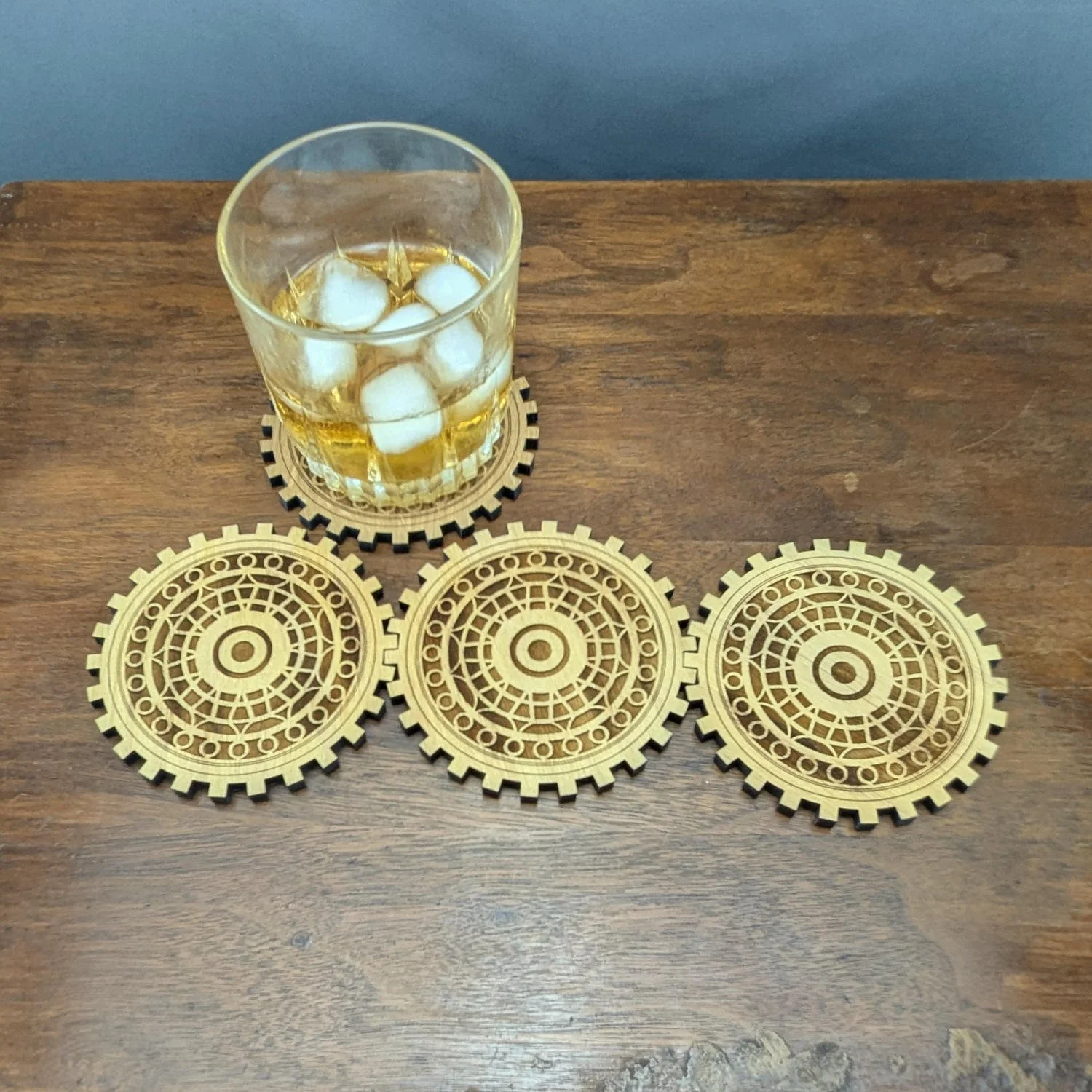 Draftsman coaster under a glass of iced whiskey