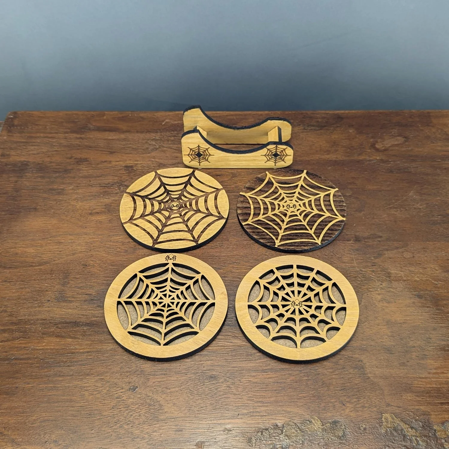 Four spiderweb wooden coasters with different designs and matching engraved holder, handmade from Black Locust wood.