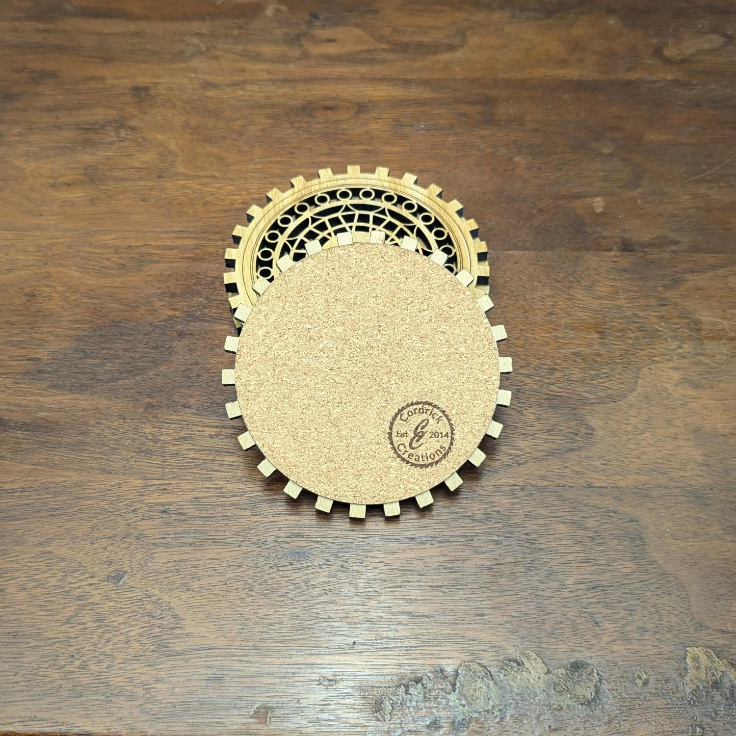 Back view of The Precisionist wooden coaster showing cork backing with Cordrick Creations logo stamp.