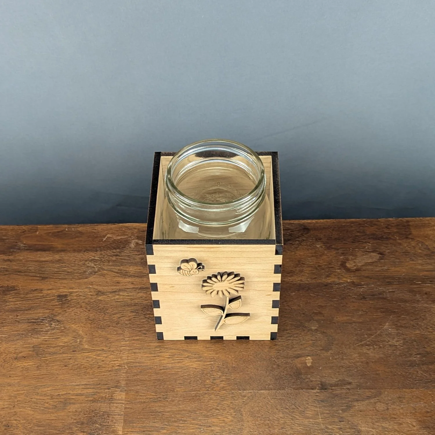Top-down view of maple vase sleeve with mason jar inserted, showing precise box-joint corners and laser-cut details