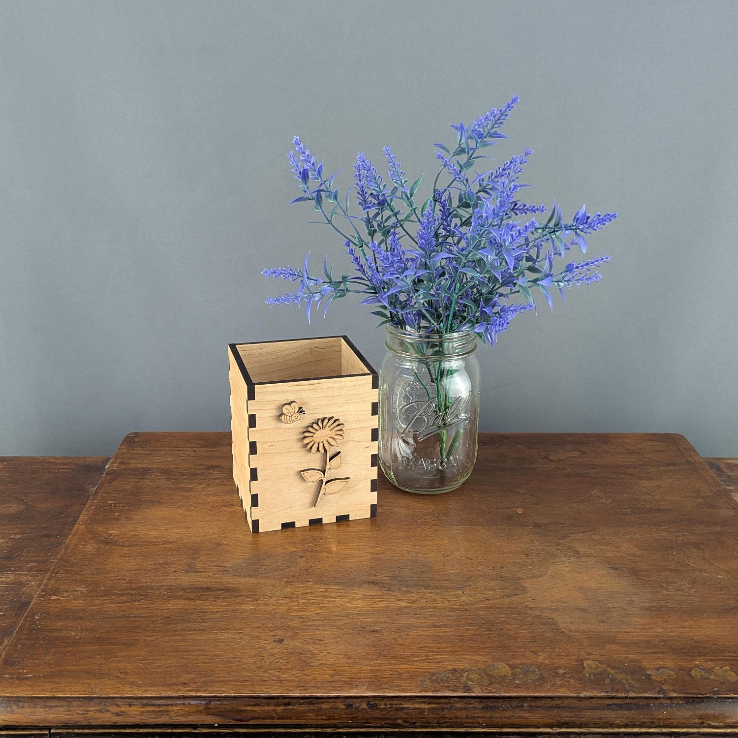 Maple Bloom & Buzz vase box displayed beside mason jar with lavender arrangement on rustic wooden table.