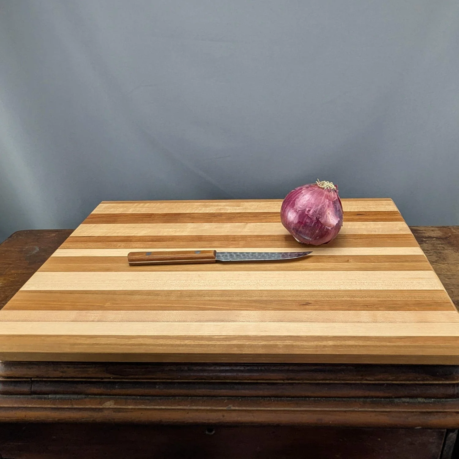 Maple and cherry cutting board with onion and knife
