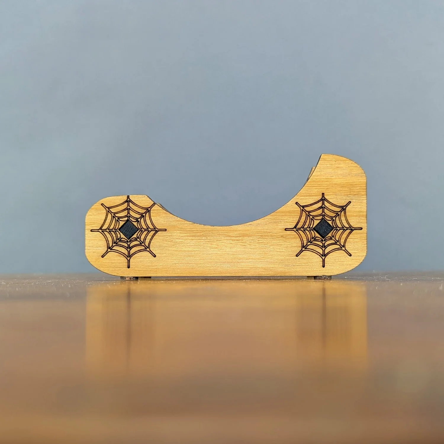 Straight-on view of Webworks Coaster Holder, engraved with twin spiderweb designs