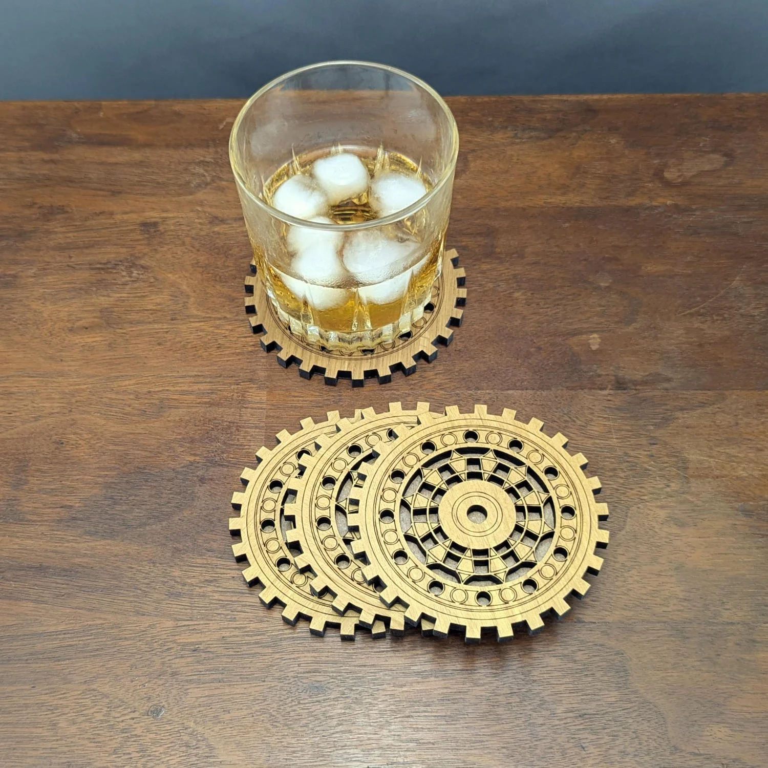 Machinist coaster under a glass of iced whiskey