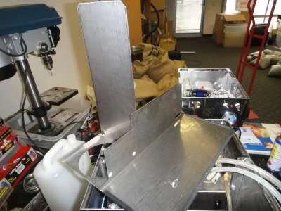 Now it's possible to lift the top off the machine. Carefully ease the hoses out of their slot.&nbsp; WARNING!! The body panels are laser cut stainless steel, and the edges are razor sharp! Take care not to get cut!