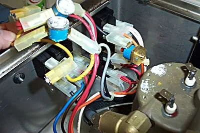 Begin by removing the thermostats and element leads.   The overtemperature (red button) thermostat unscrews out of the body of the boiler.