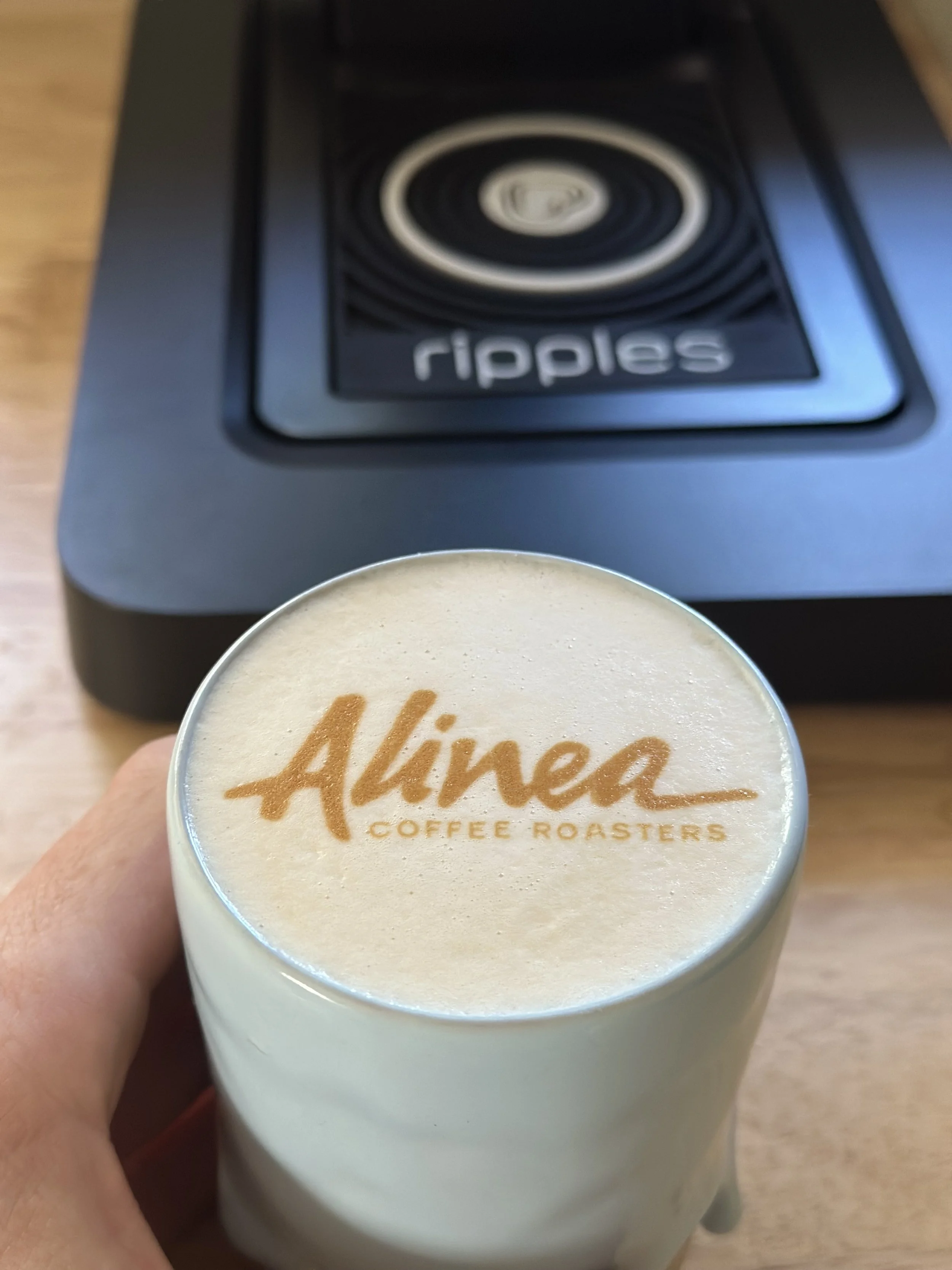 Latte art with the Alinea logo printed on the foam