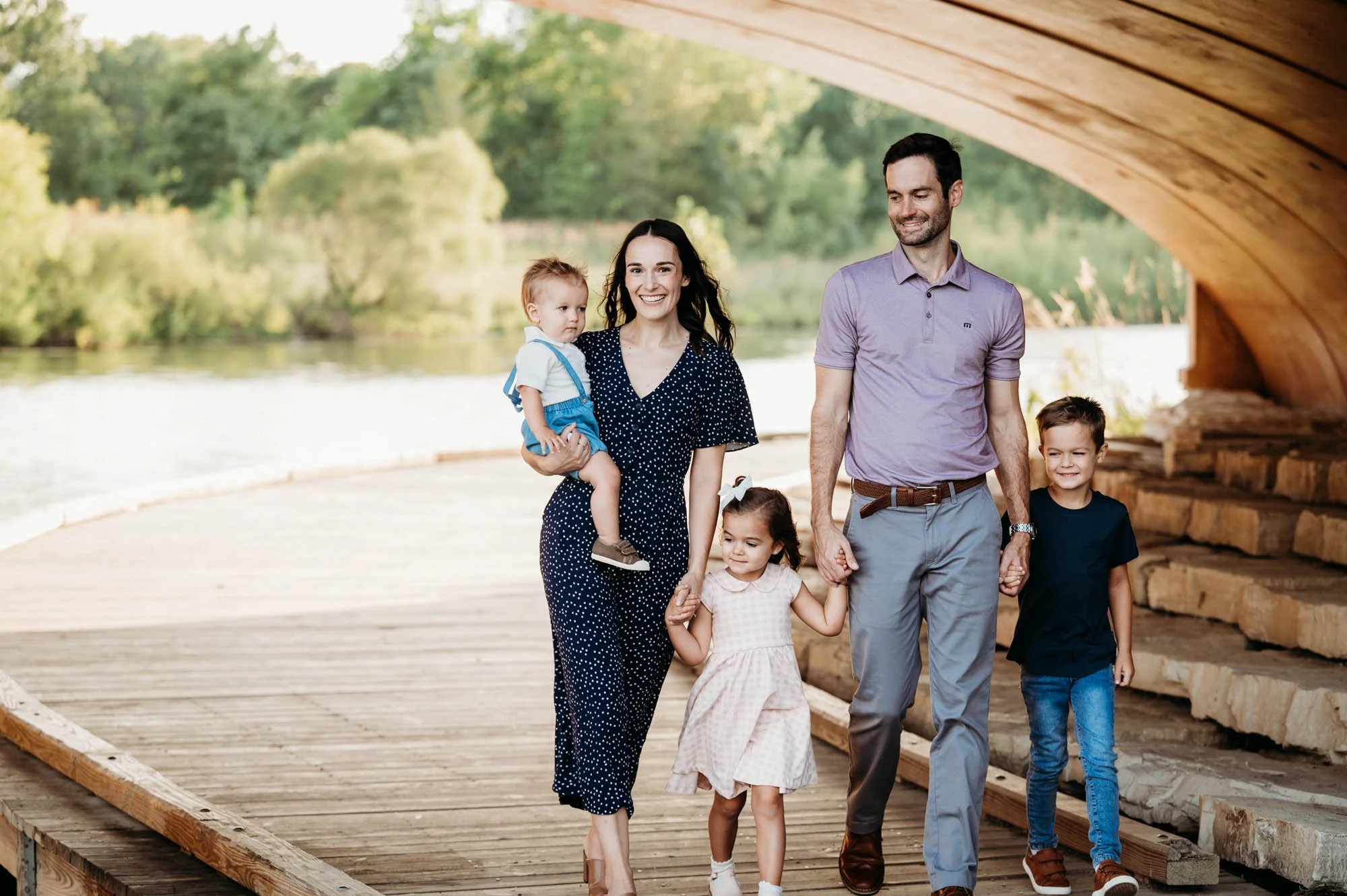 Family of five walking together under a bridge during an outdoor family photography session in Noblesville, Indiana