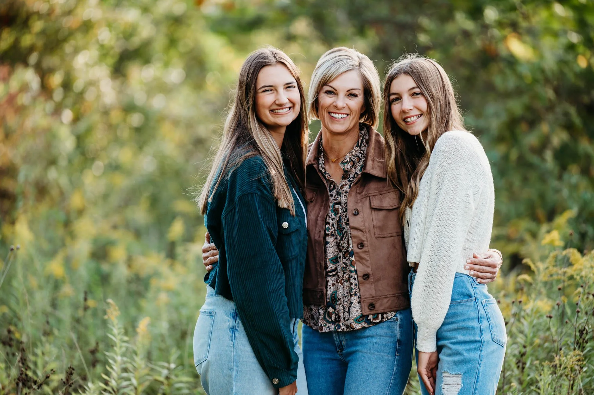 mom hugging her two teen daughters during family photoshoot in Fishers, Indiana