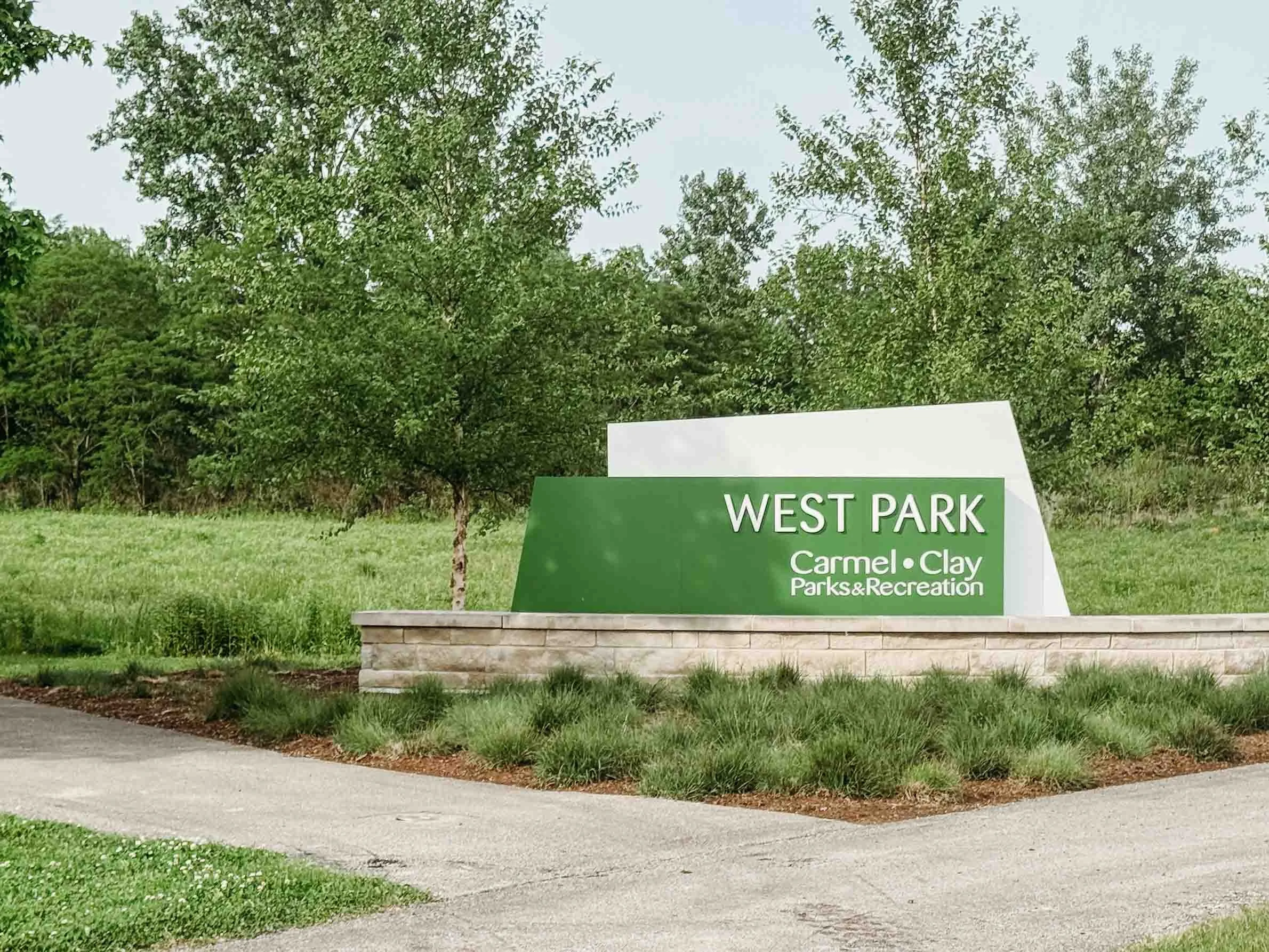 West Park entrance sign with trees, grass, and landscaping in Carmel, Indiana.