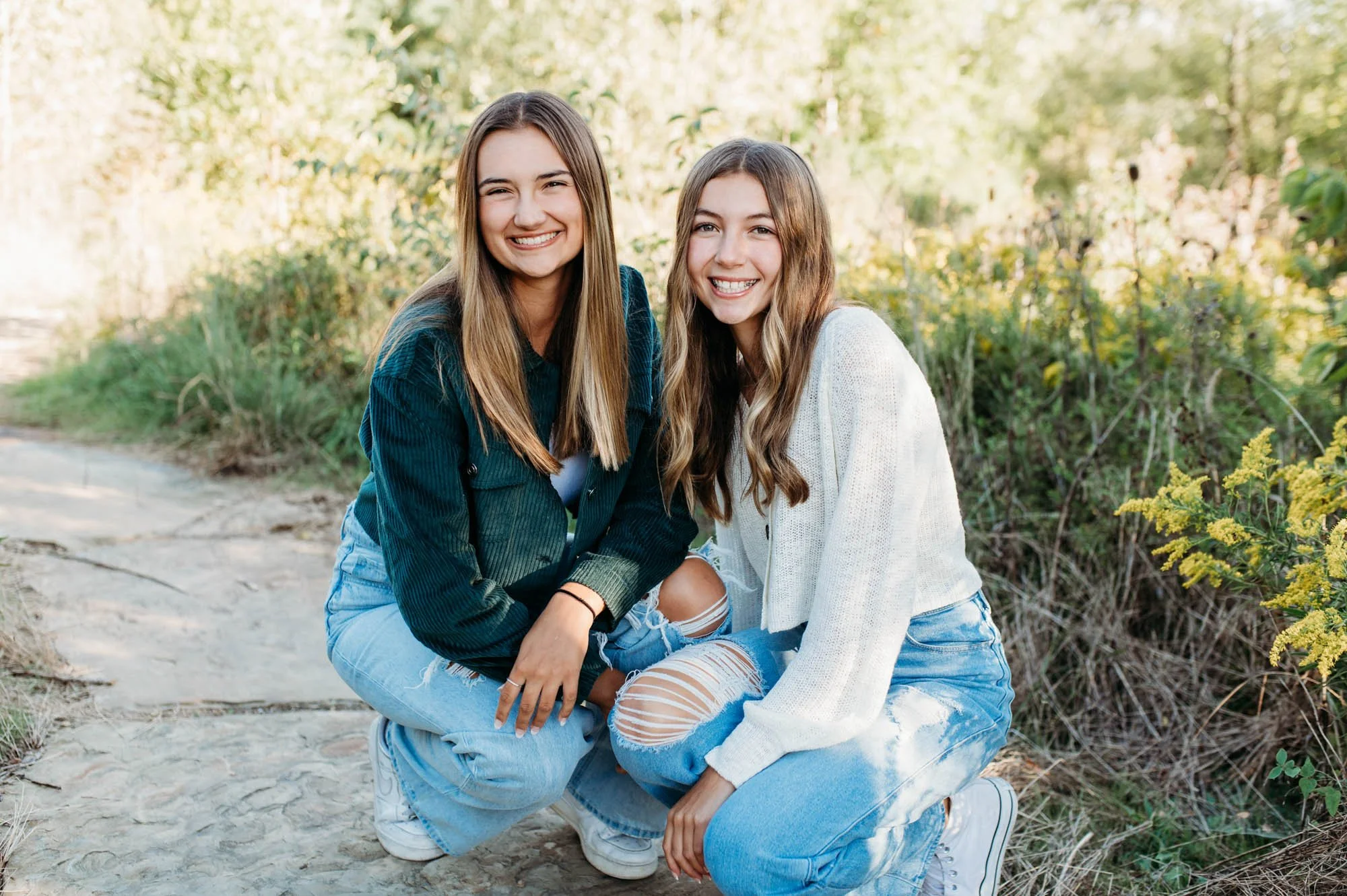 teen sisters kneeling together during Fishers, Indiana family photos