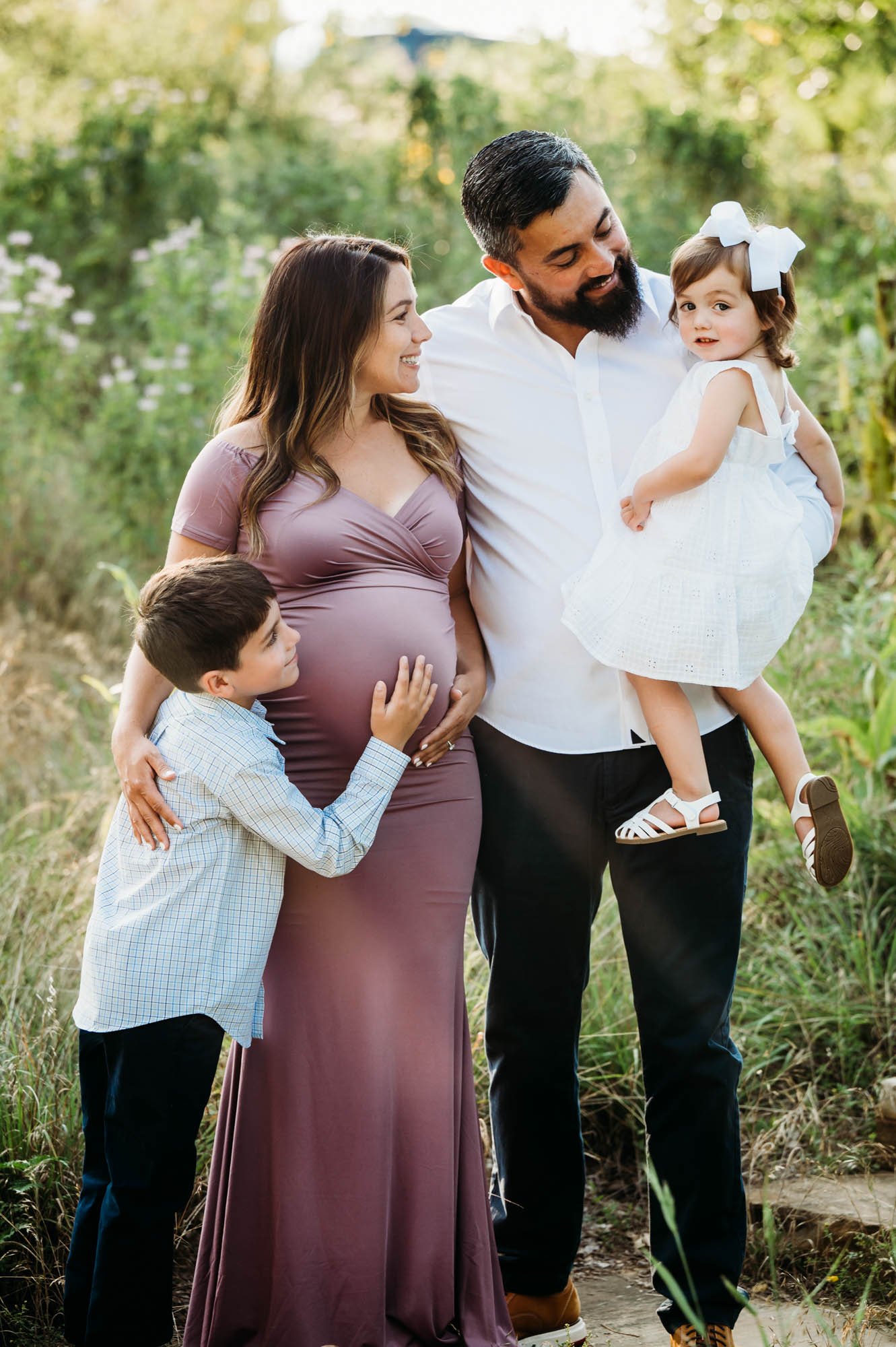 Family of four standing together during maternity photoshoot in Carmel, IN