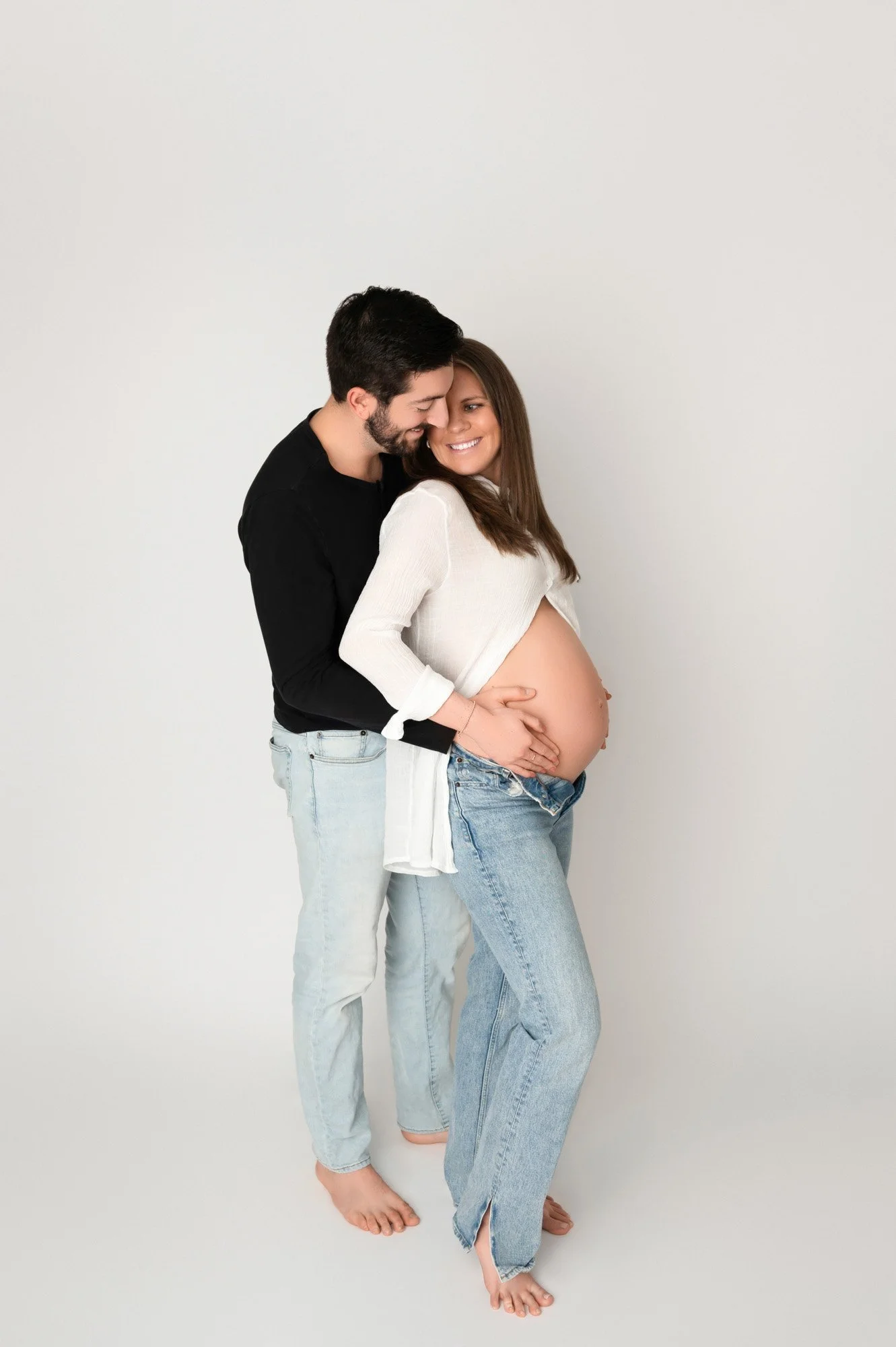 young couple expecting baby with Dad hugging from behind in noblesville maternity photoshoot