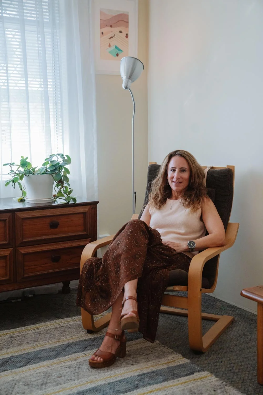 Emily Hirshman-Smith, Cottesloe Counsellor and Psychotherapist, sitting in an armchair wearing a brown skirt and cream top