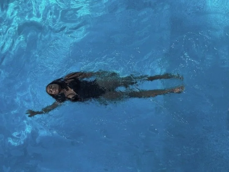 Black girl swimming in a clear blue pool