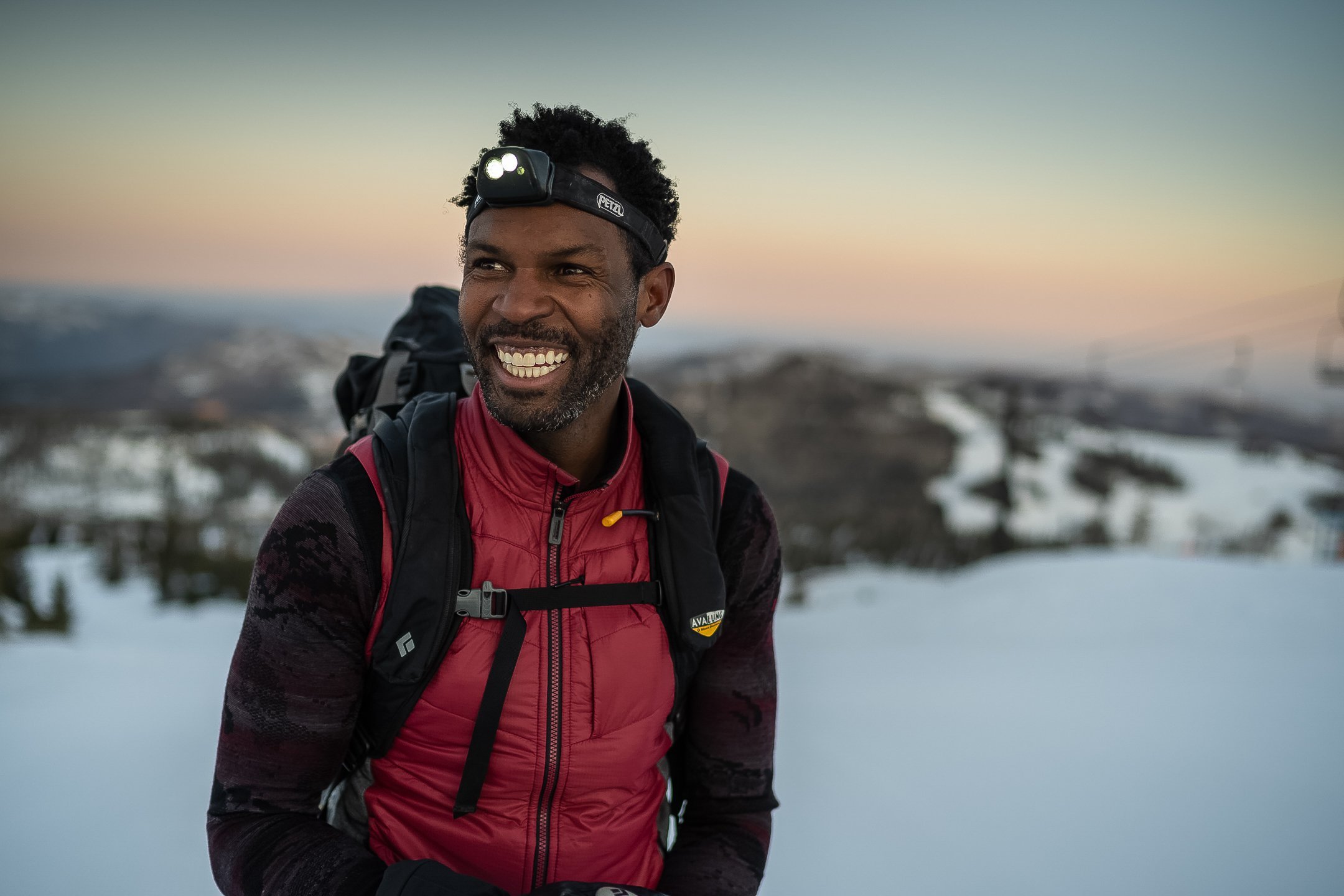 man-with-headlamp-smiles-in-snow.jpg